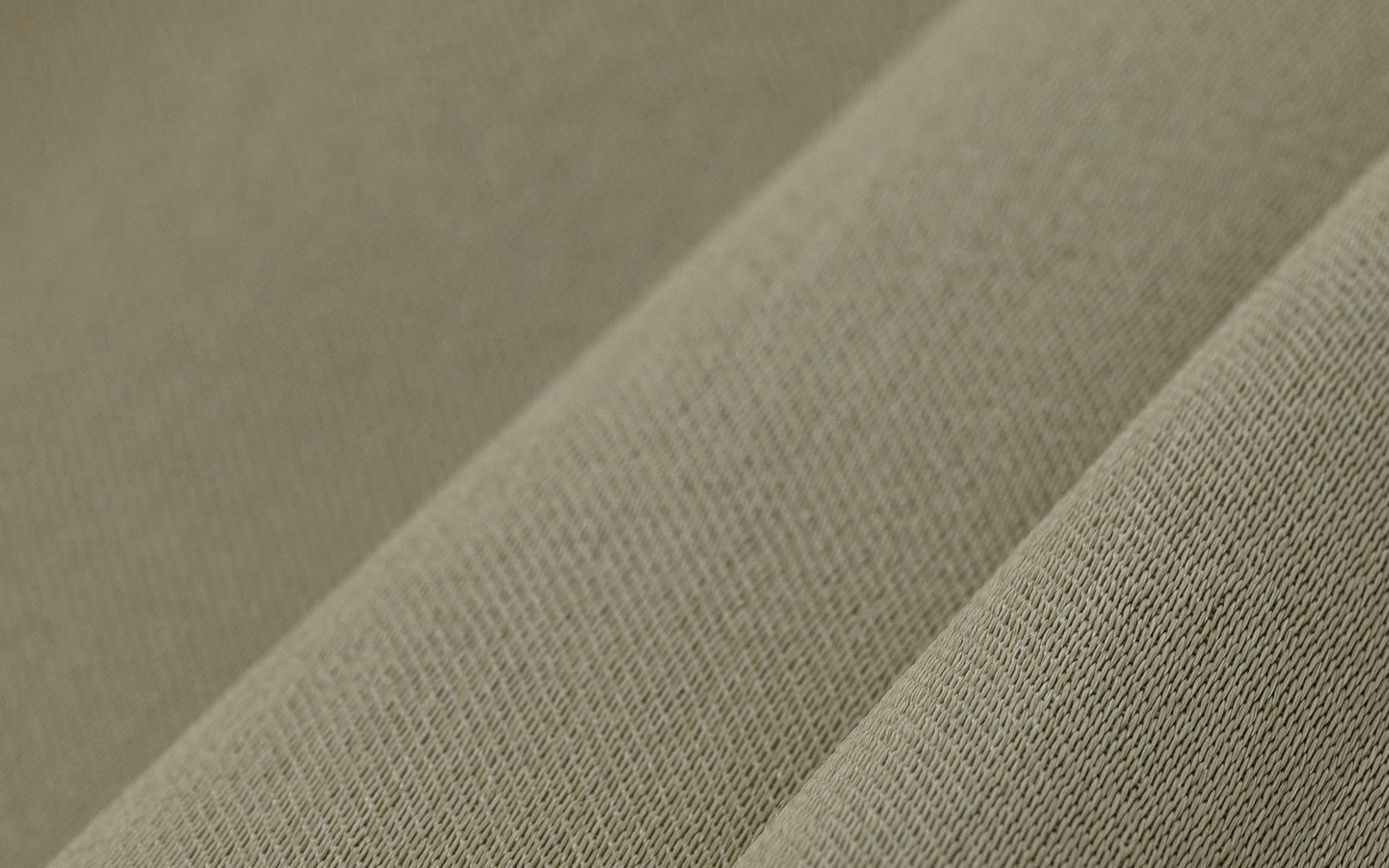 Close-up of folded beige fabric showing its woven texture and soft appearance.