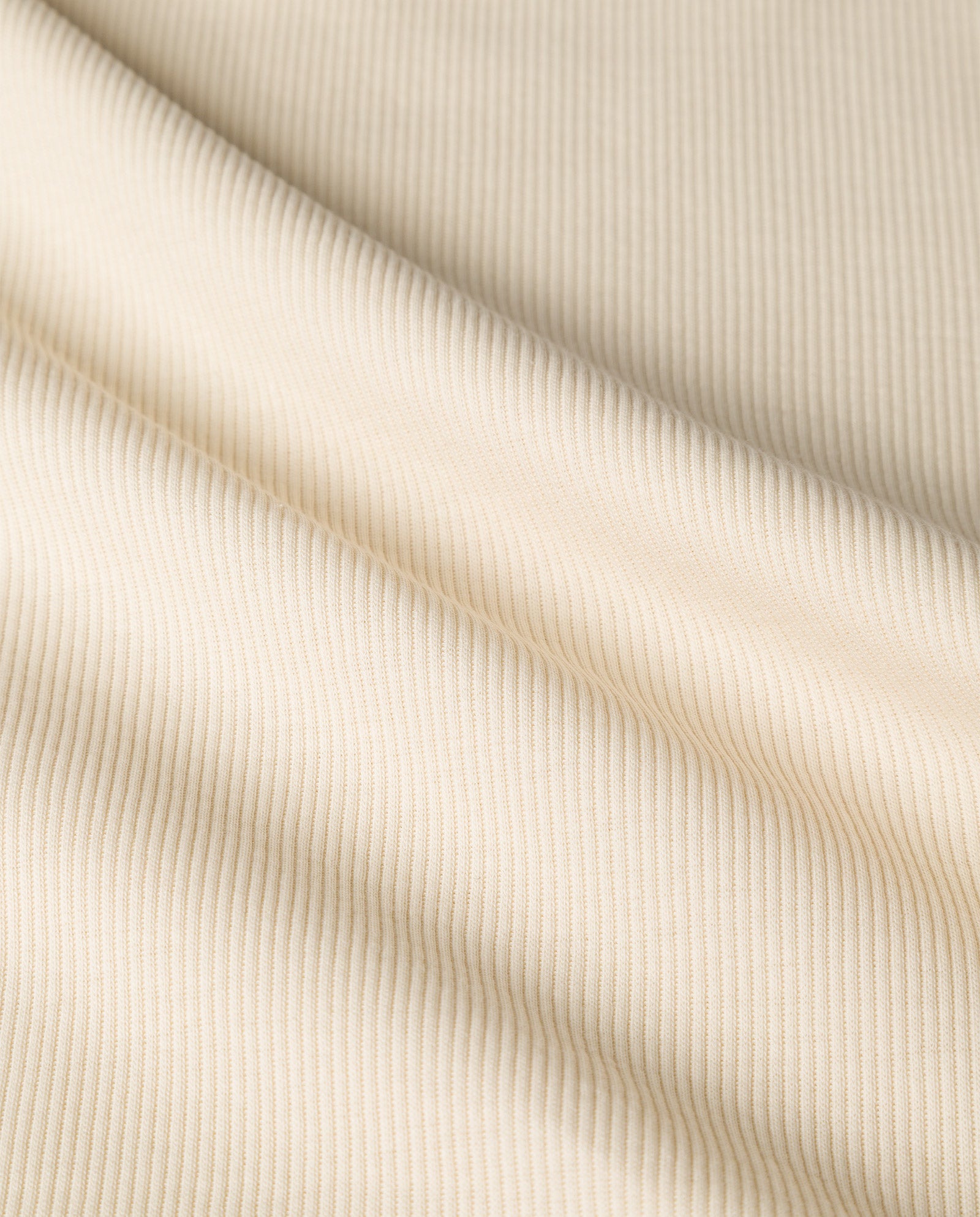 Close-up of beige ribbed organic cotton fabric with diagonal lines and soft folds, featured in the IVY OAK KLARA ANN Tanktop.