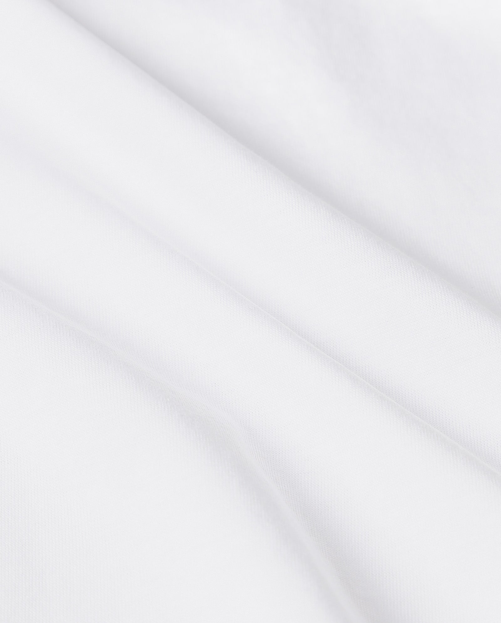 Close-up of white organic cotton fabric with soft diagonal folds and smooth texture—ideal for the KYLA Top by IVY OAK, making it a must-have for those who value comfort and style.
