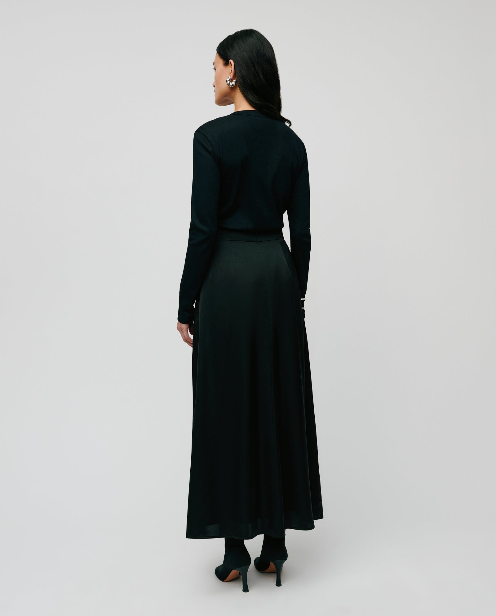 A woman wearing the IVY OAK KOLLINA Top, crafted from comfortable Organic Cotton, stands with her back to the camera against a plain background.