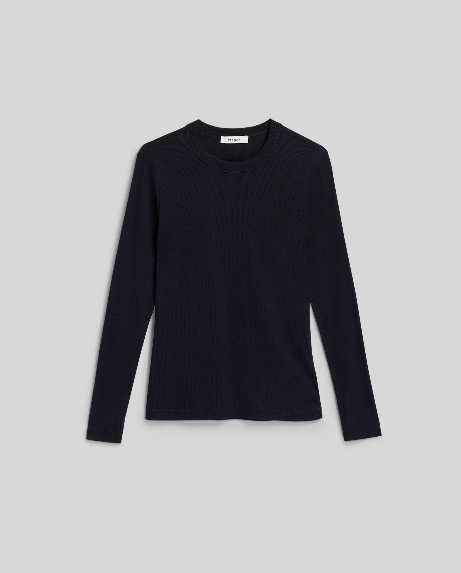 The IVY OAK KOLLINA Top is a black, long-sleeve round-neck t-shirt crafted from organic cotton, shown laid flat on a plain light gray background for a comfortable look.