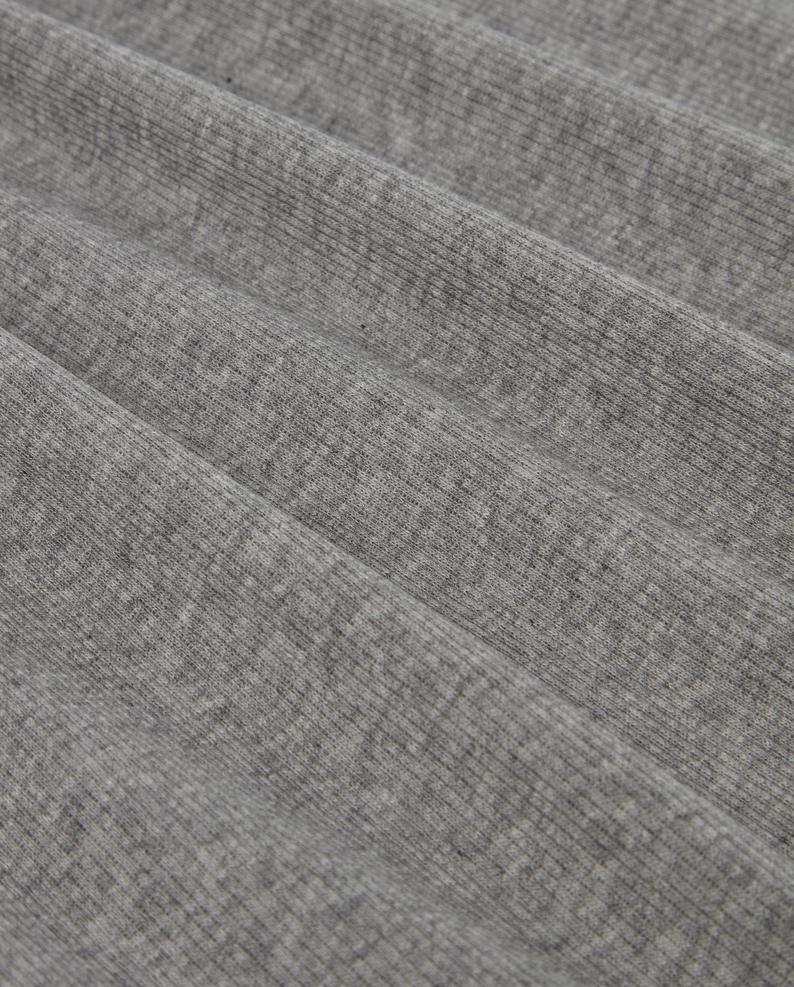 Close-up of the KOLLINA Top by IVY OAK, featuring folded gray ribbed fabric with a textured grid-like pattern—ideal for a comfortable round neck shirt made from organic cotton.