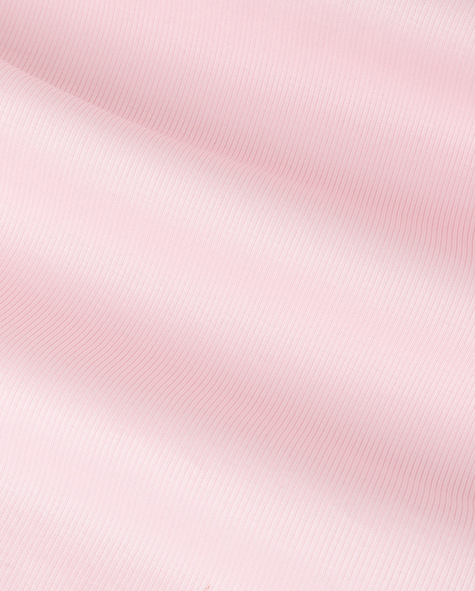 The KLARA ANN Top by IVY OAK features light pink organic cotton fabric with a subtle ribbed texture and soft folds, ideal for comfortable wear.