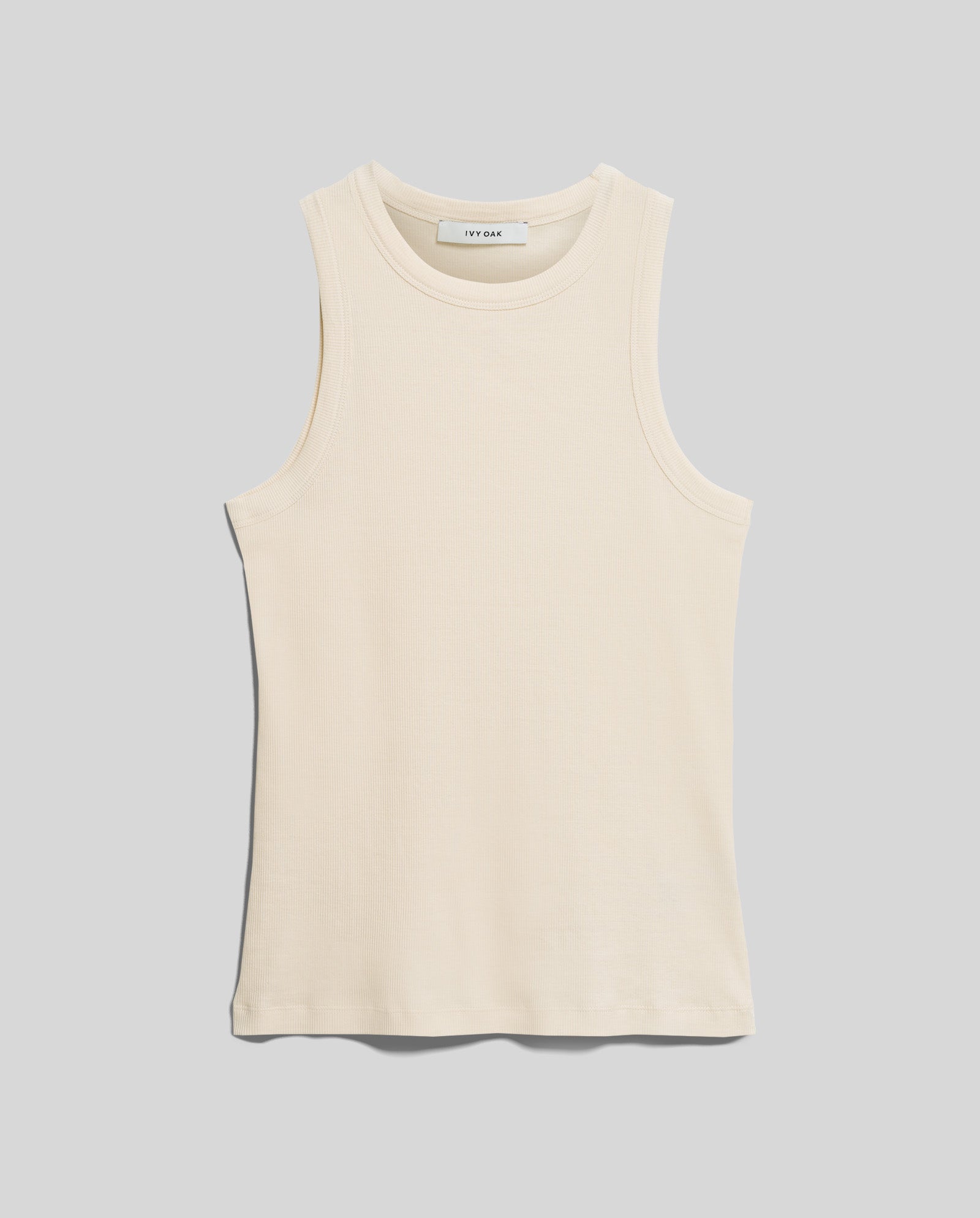 The IVY OAK KLARA ANN Top is a sleeveless, off-white ribbed tank crafted from soft organic cotton with a crew neckline, shown against a plain gray background.