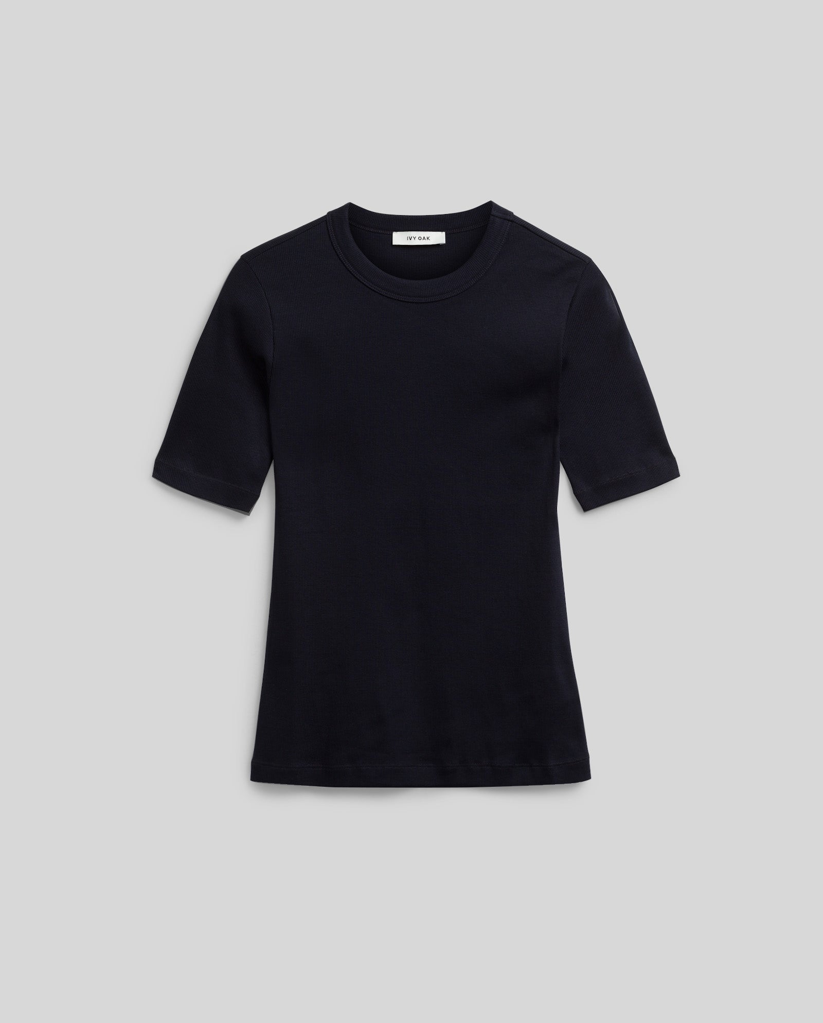 The IVY OAK KRISTIN Top, a comfortable black short-sleeve crew neck T-shirt, is displayed laid flat on a light gray background.