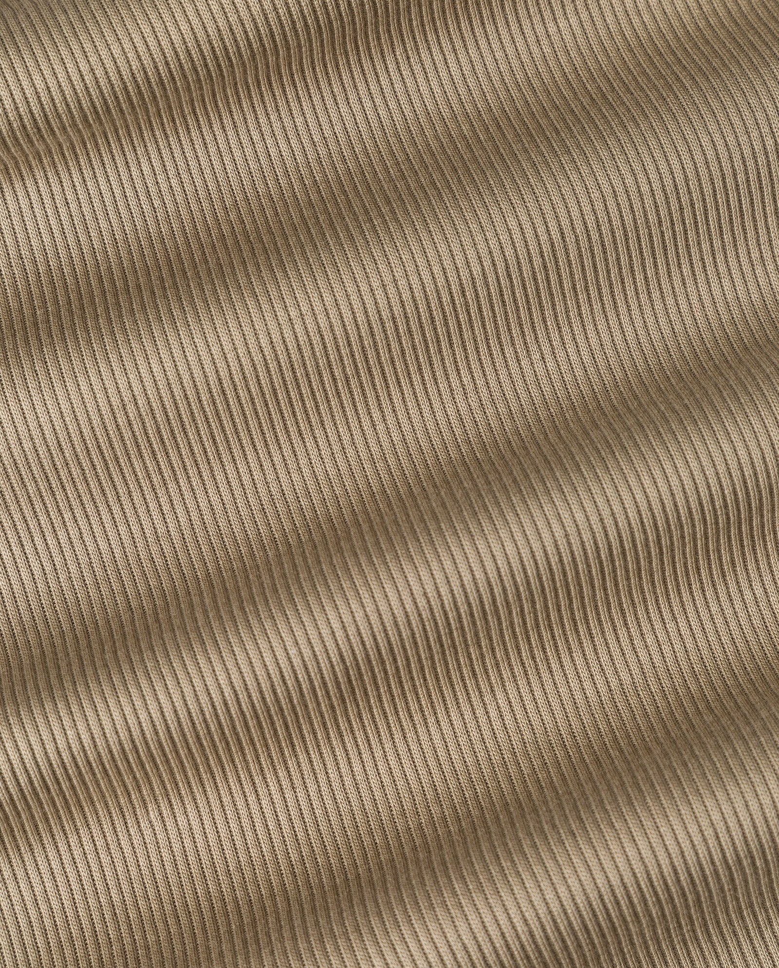 Tan ribbed fabric with diagonal lines and gentle shadows forms a wavy, textured look—just like the IVY OAK KRISTIN Top, designed for all-day comfort.