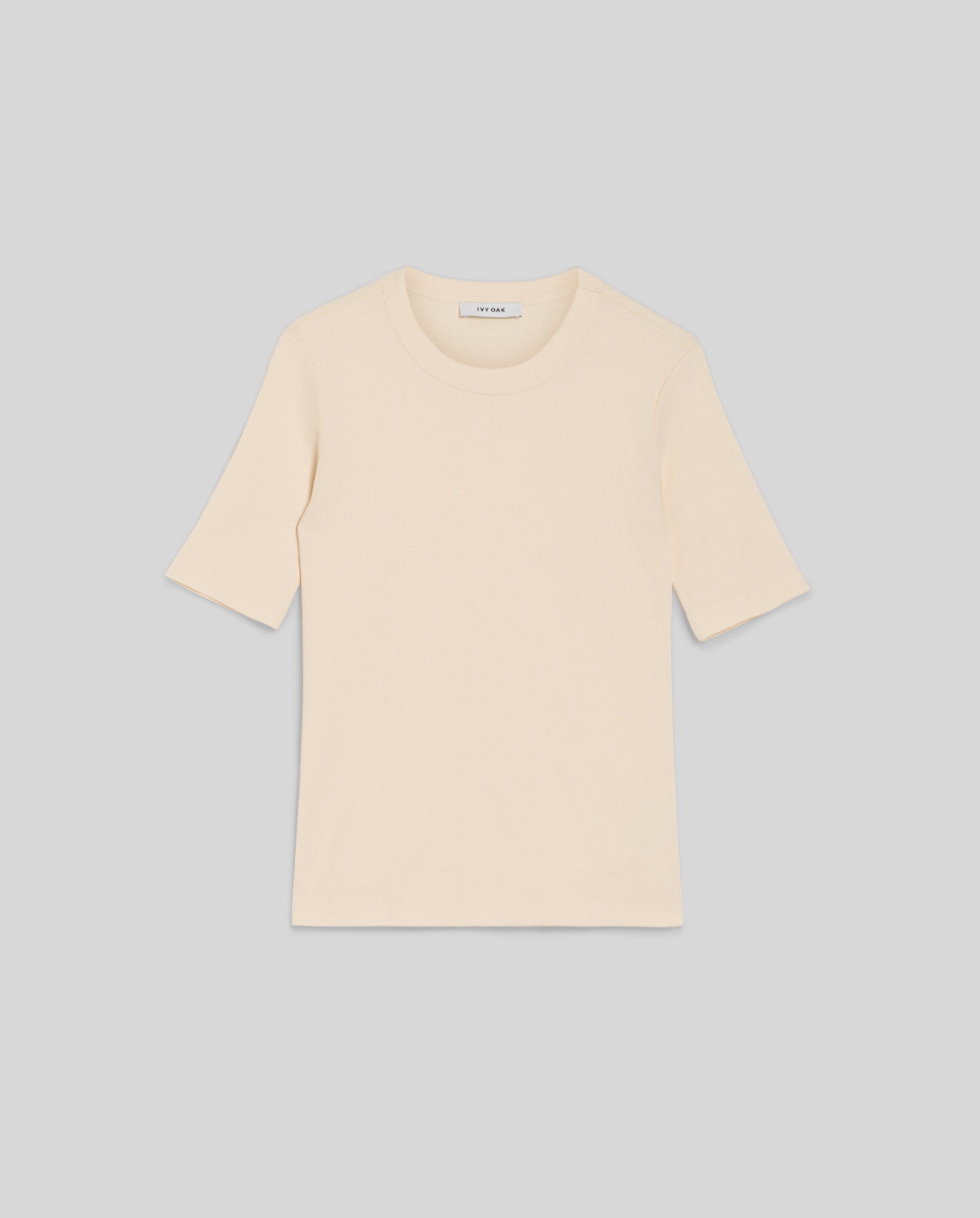 A plain, short-sleeved KRISTIN Top by IVY OAK in light beige, crafted from comfortable organic cotton, displayed on a gray background.