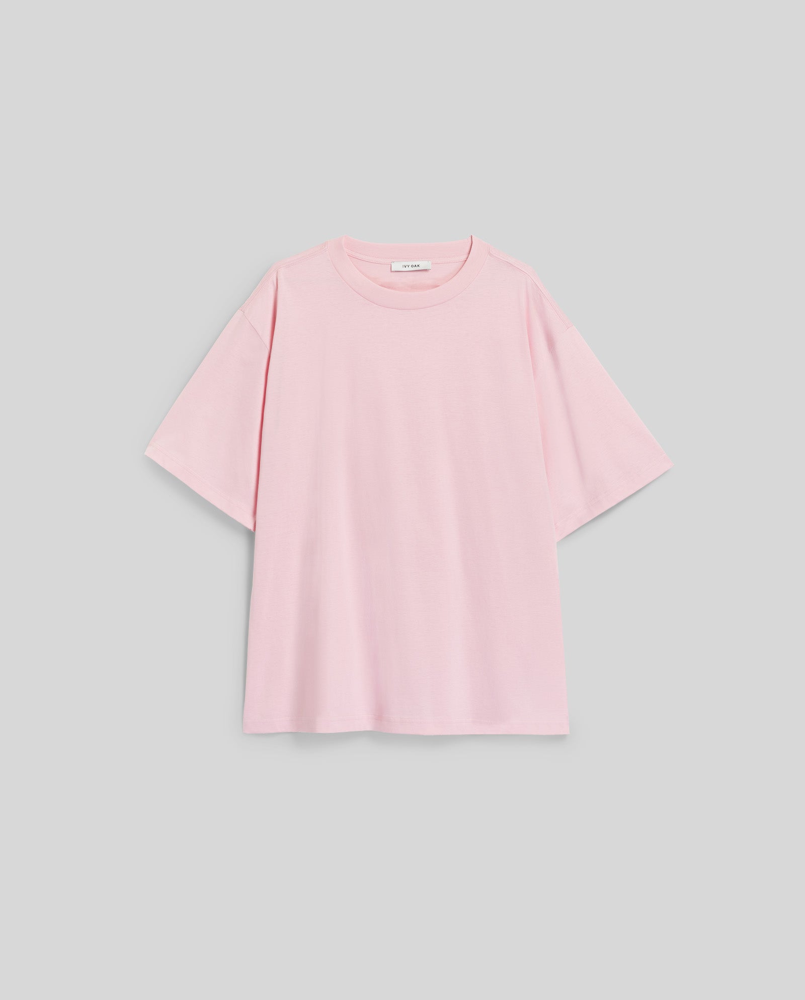 The IVY OAK KYLA ROSE Top is an ultra-soft, light pink T-shirt with short sleeves and a loose fit, shown laid flat on a light gray background.