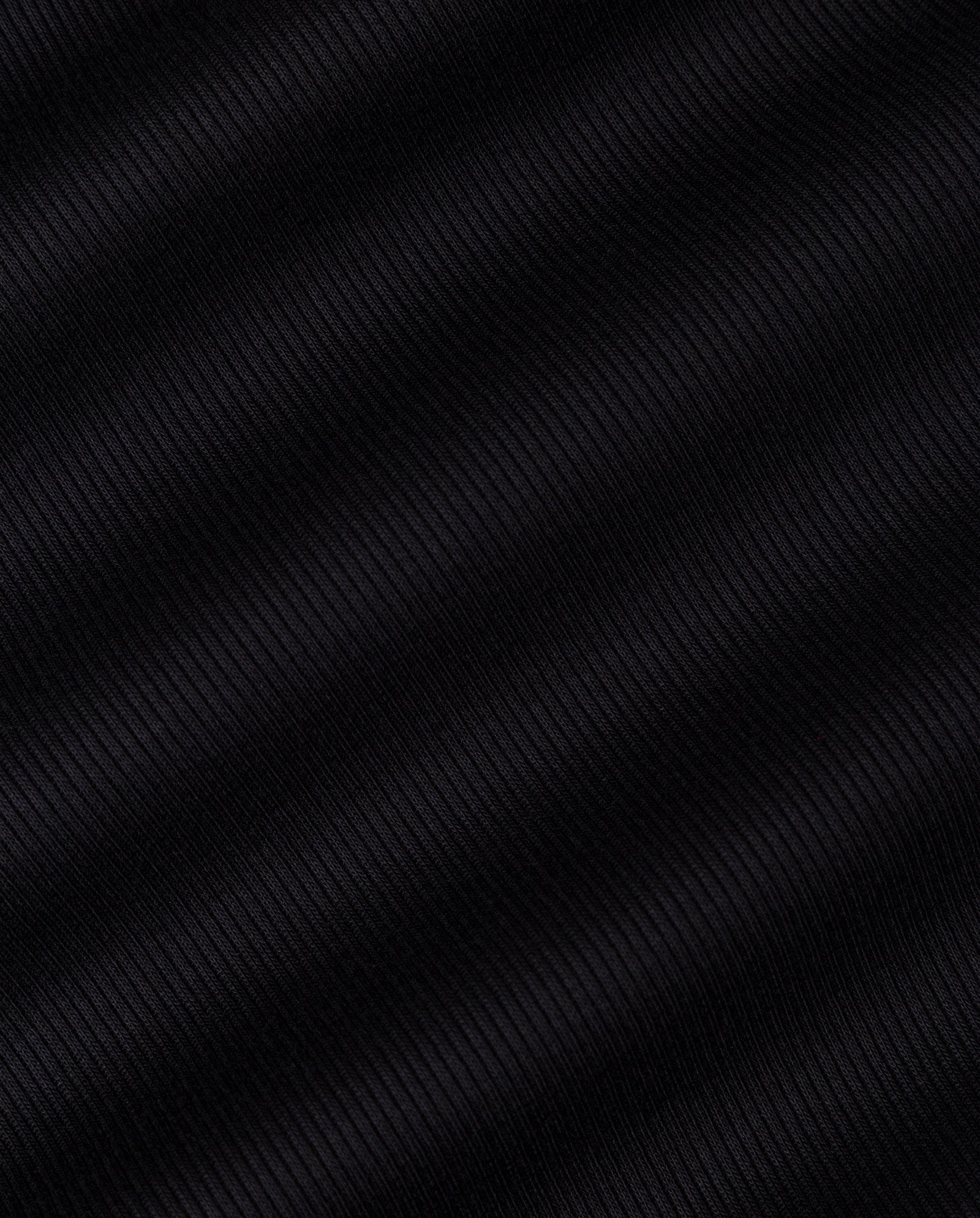 Close-up of black ribbed fabric with diagonal textured lines in classic ripp-optic, featured in the IVY OAK KLARA ROSE Top—perfect for a tank top with a narrow shoulder design.