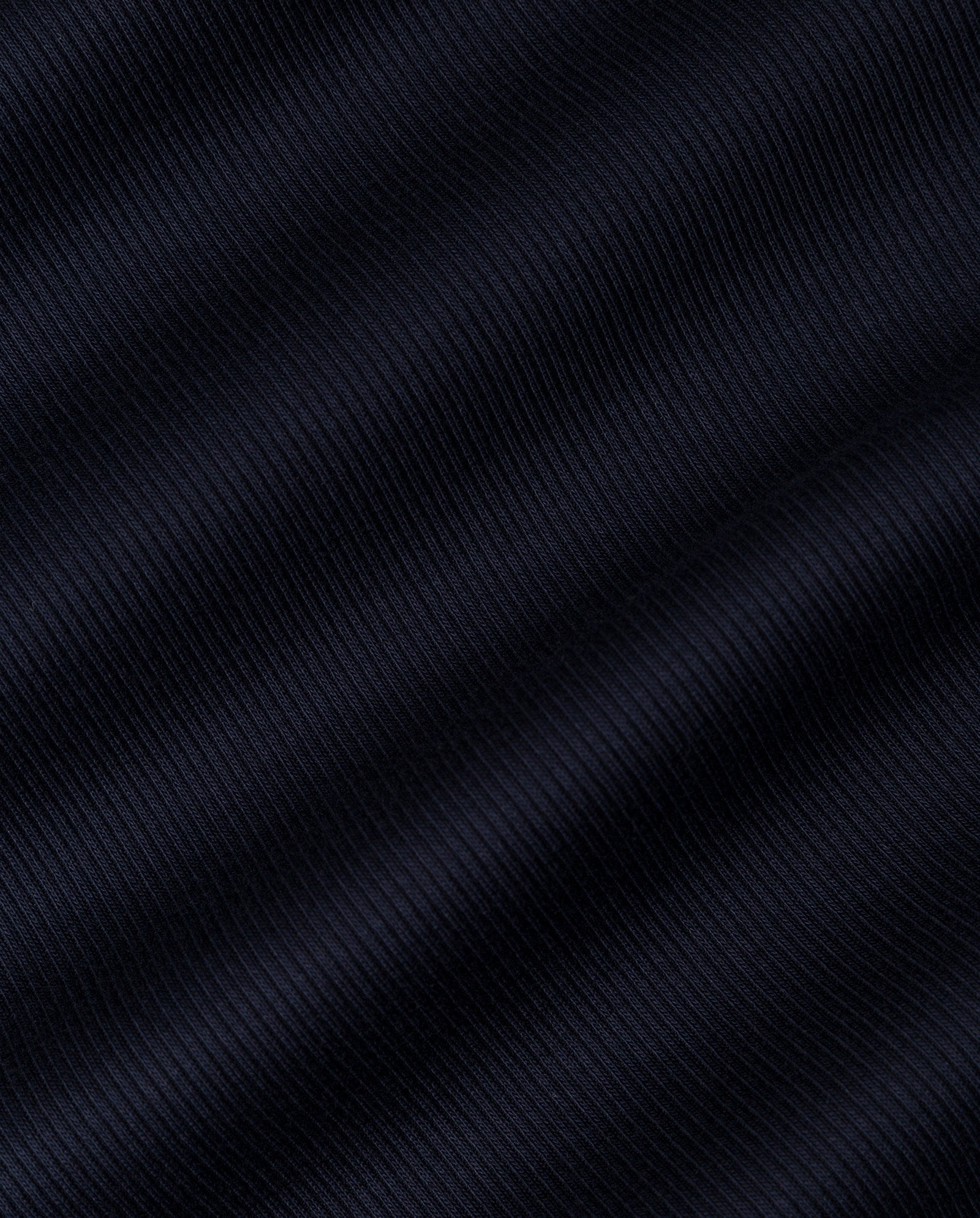 Close-up of the KLARA ROSE Top by IVY OAK, featuring dark ribbed fabric with diagonal textured lines and soft shadows, highlighting a ripp-optic pattern—ideal for its narrow shoulder tank top design.