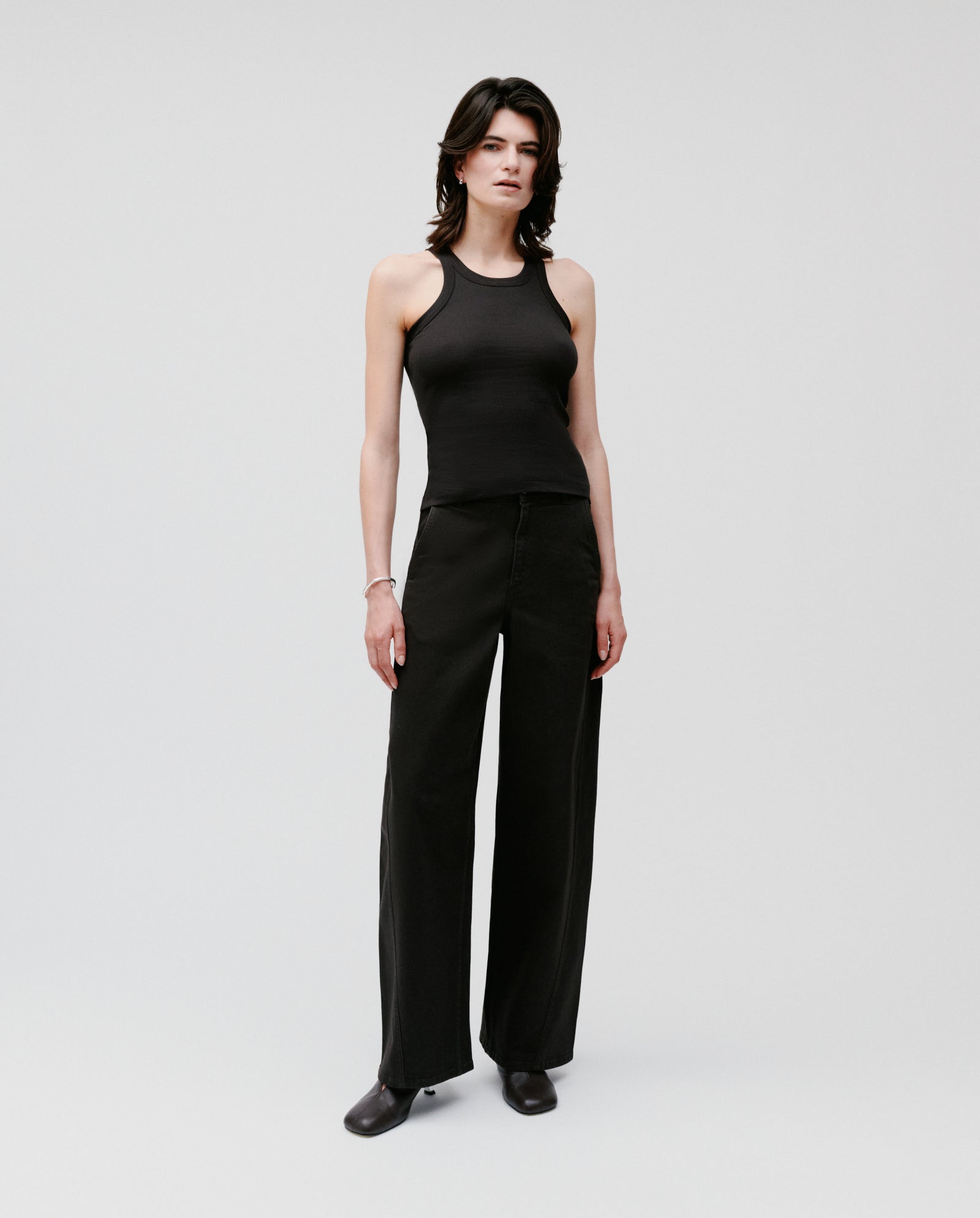 Person wearing the IVY OAK FINLEY Top, black wide-leg pants, and black shoes, standing against a plain background.