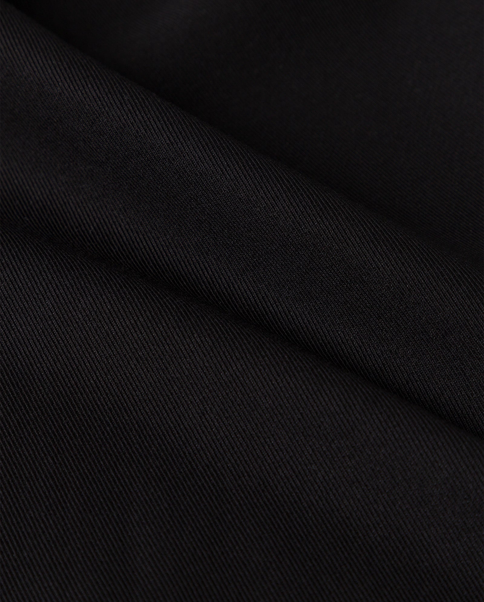 Close-up of the PEONY ROSE Trouser by IVY OAK, featuring smooth black viscose blend fabric with diagonal folds and a fine, subtle texture.