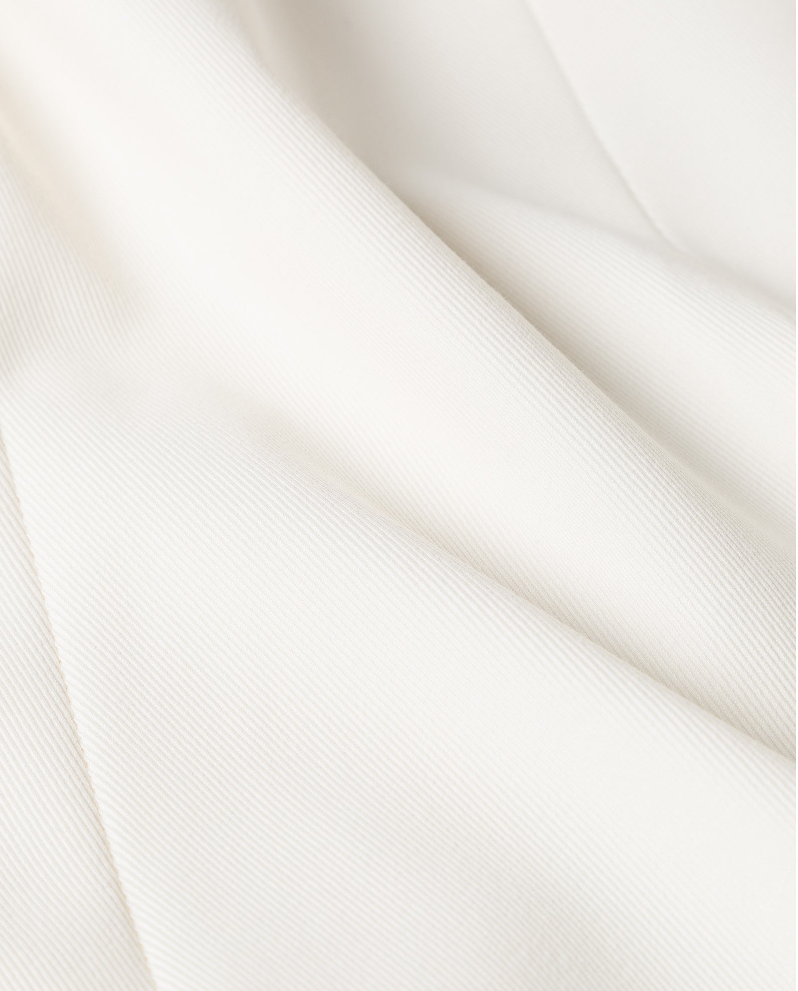 Close-up of the PEONY ROSE Trouser by IVY OAK, featuring soft, white, textured viscose blend fabric with gentle folds and diagonal lines.