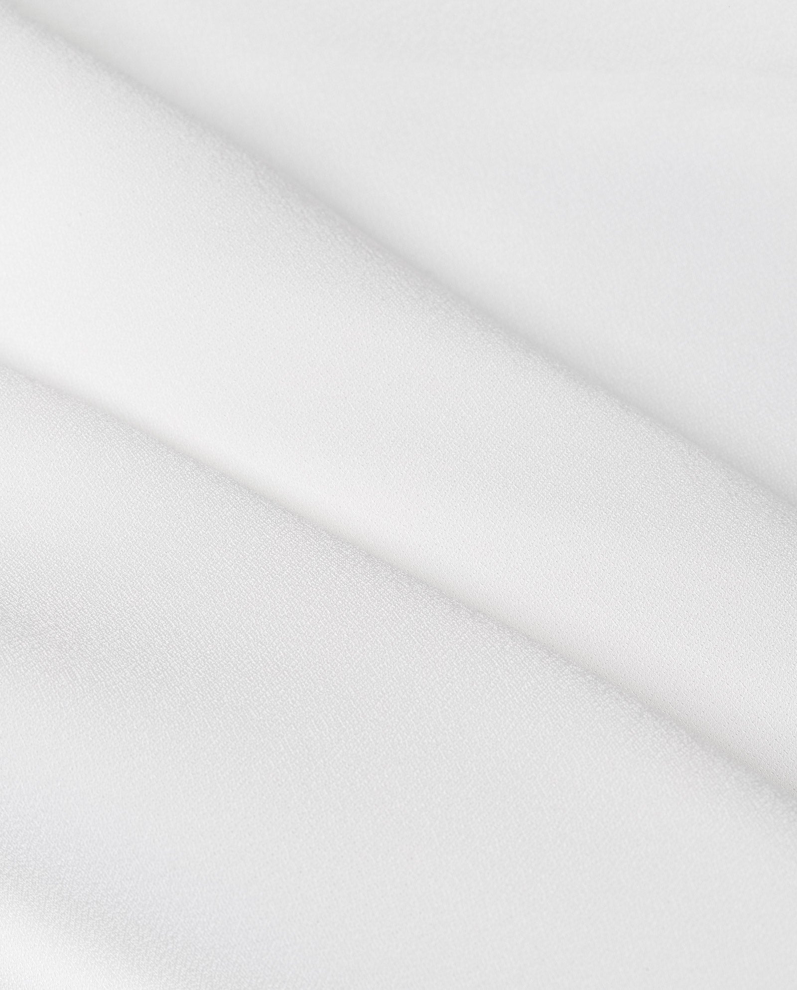 Close-up of smooth, white fabric with soft texture and gentle folds, ideal for the elegant MEREDITH Bridaldress by IVY OAK or a wedding dress featuring graceful godets.
