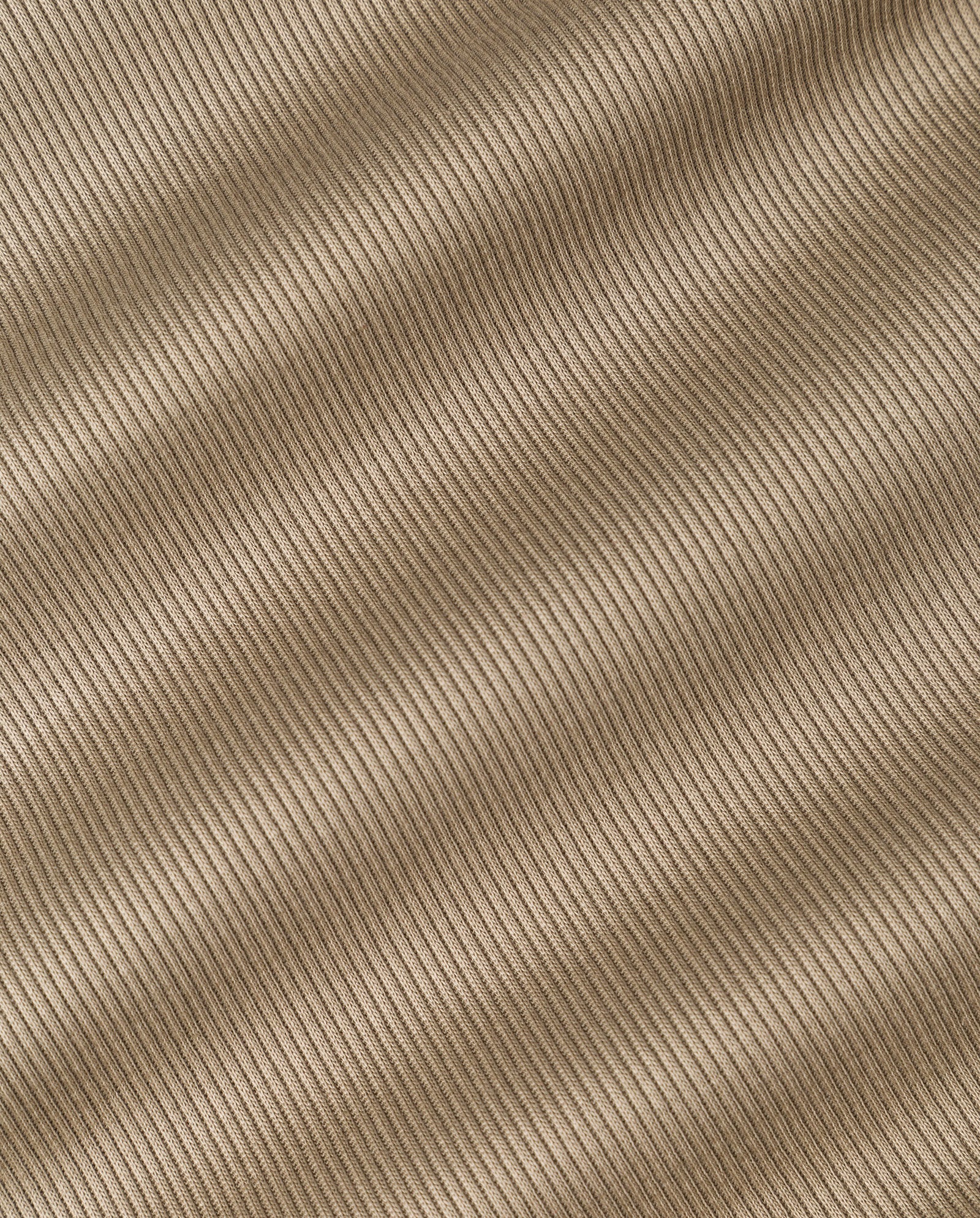 Close-up of ribbed beige fabric with diagonal textured lines and gentle folds on the IVY OAK KRISTYNA Dress, perfect for a chic and flattering look.