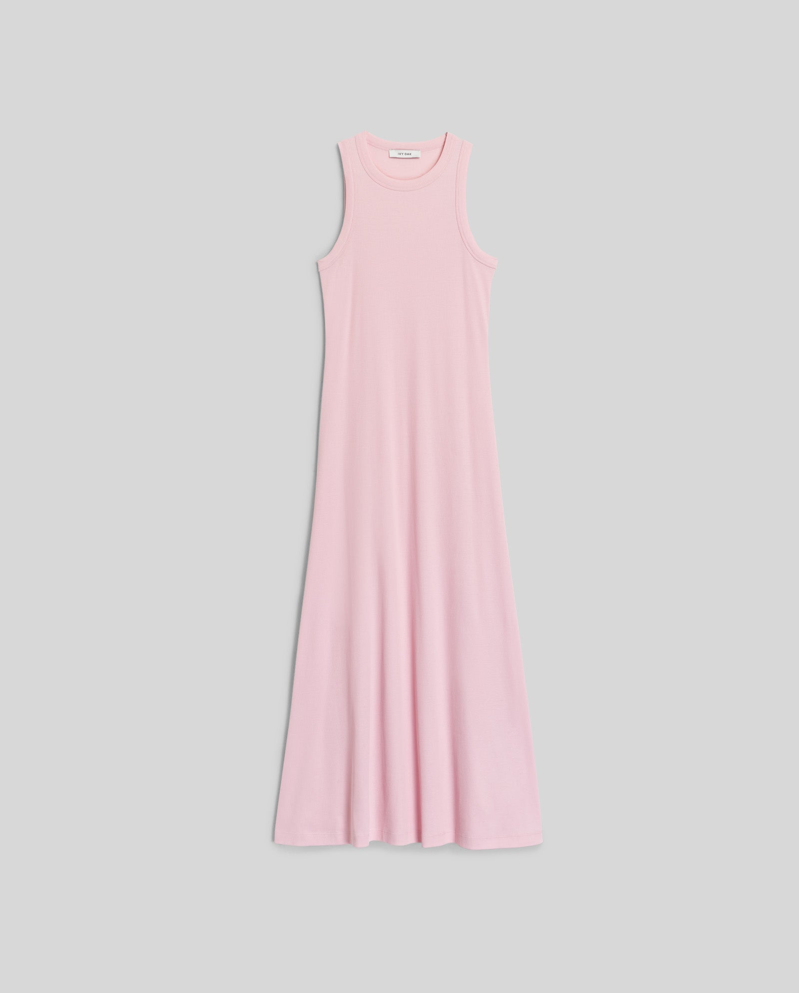 The IVY OAK KRISTYNA Dress is a sleeveless light pink ribbed knit maxi with a round neckline and flared skirt, displayed flat on a light gray background.