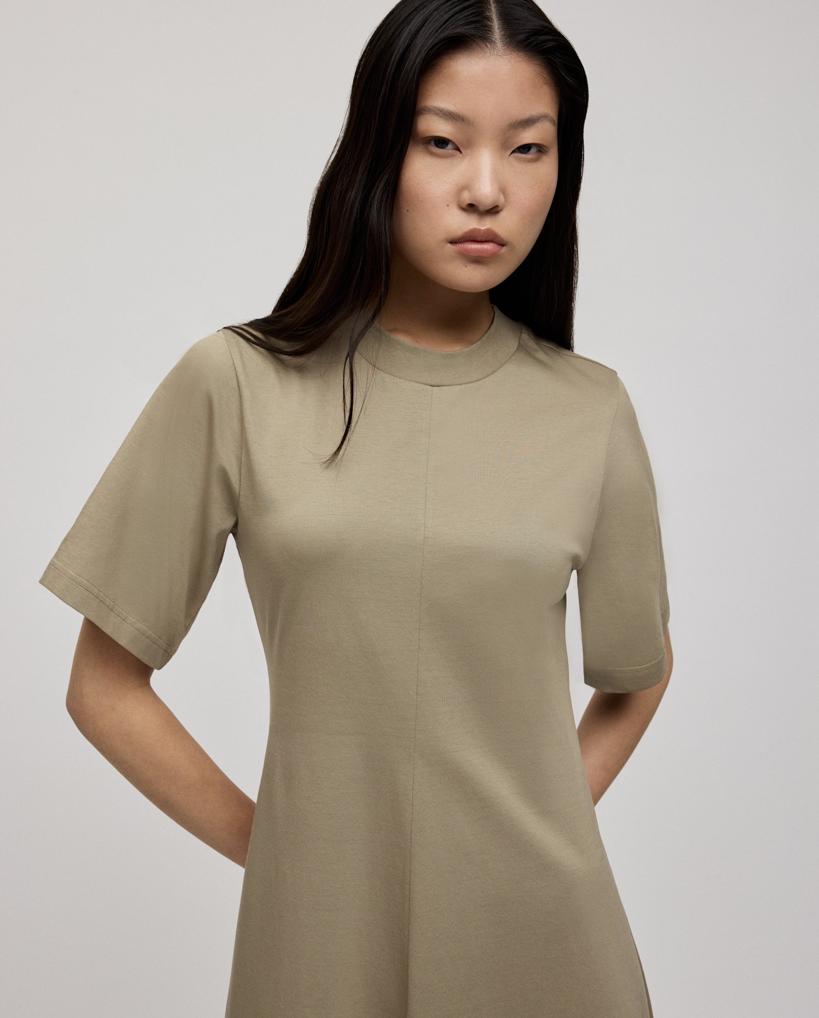 A woman wears the IVY OAK FRANZISKA Jersey Dress with short sleeves and a fitted silhouette, posing against a plain light background with her hands behind her back.