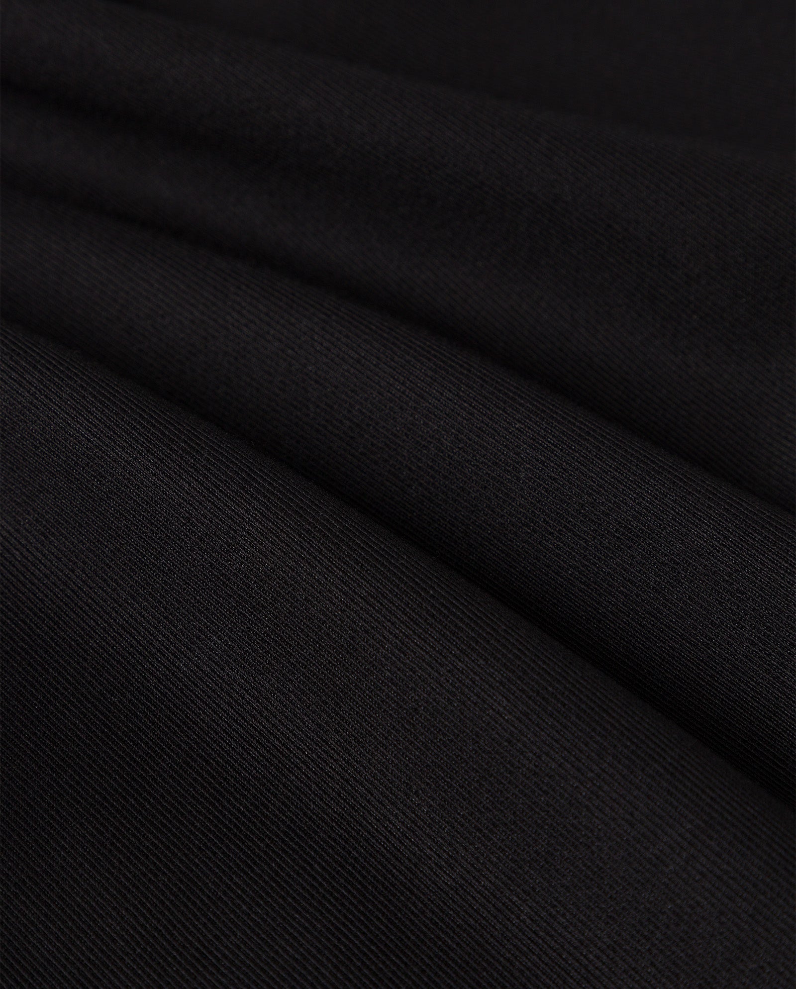 Close-up of the JIL Blazer by IVY OAK, featuring black ribbed fabric with soft folds and a smooth texture, inspired by classic tuxedo styles with a peak lapel.