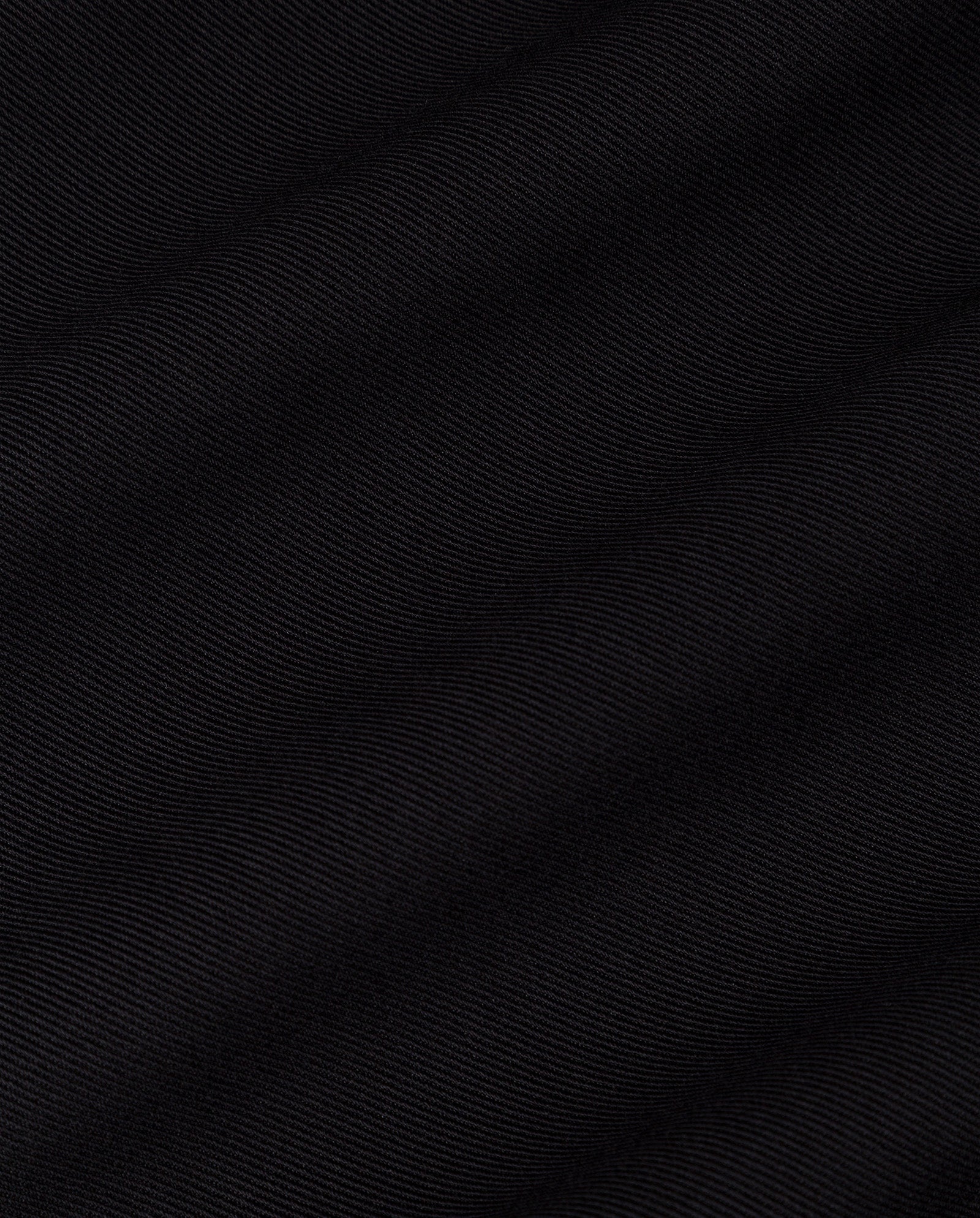 Close-up of the JIL ANN Coat by IVY OAK, featuring black fabric with subtle diagonal lines and fine texture—ideal for a transformable look or a sophisticated maxi blazer.