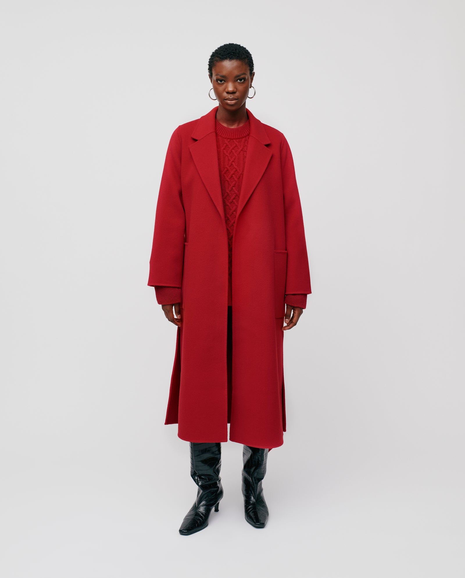 A person wearing the IVY OAK CELIA red midi wool coat, a red sweater, and black boots stands against a plain light background.