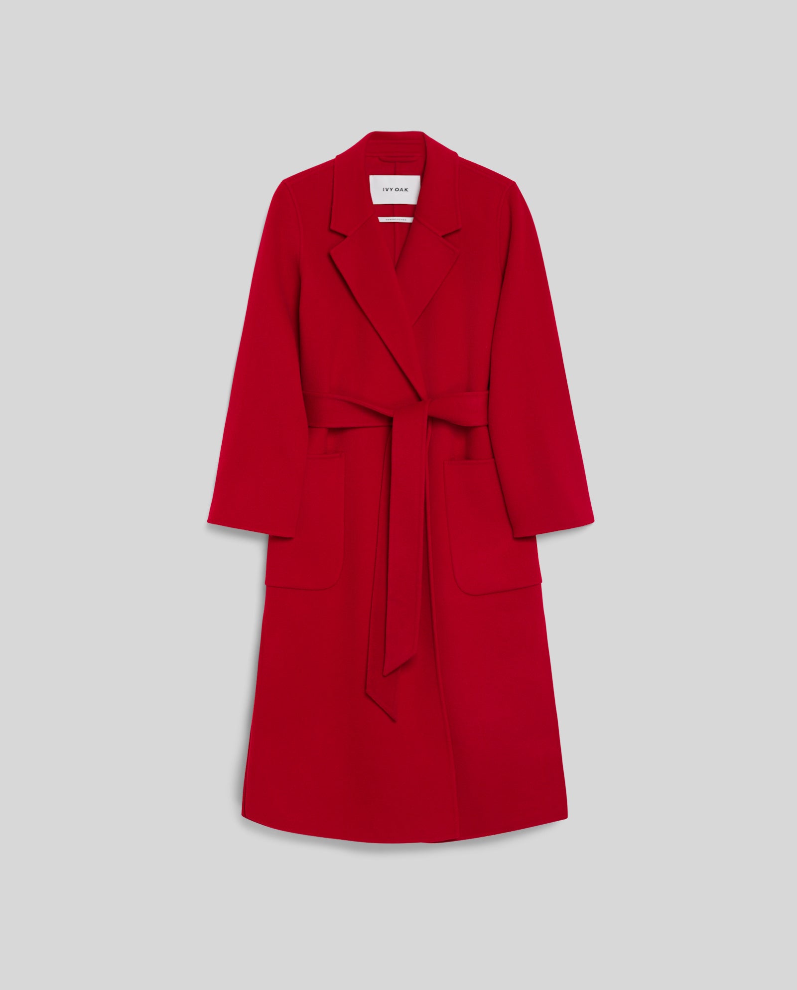 The IVY OAK CELIA Coat is a long red midi wool coat with wide lapels and large front pockets, made to the Responsible Wool Standard, shown on a light gray background.