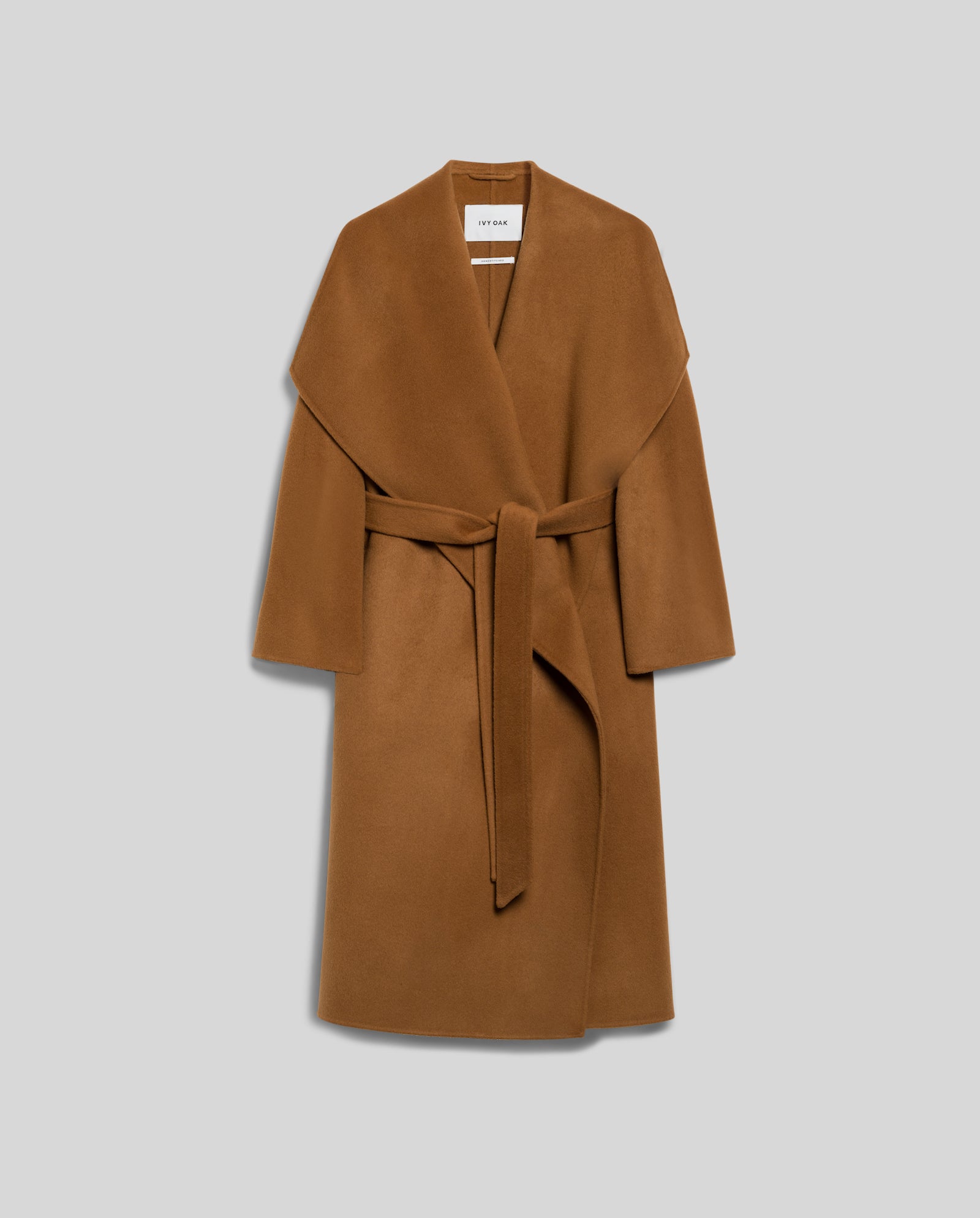 The IVY OAK CARRIE ROSE Coat is a minimalistic brown wool coat with a wide lapel collar and tie belt, made from Responsible Wool Standard-certified material, showcased on a plain grey background.