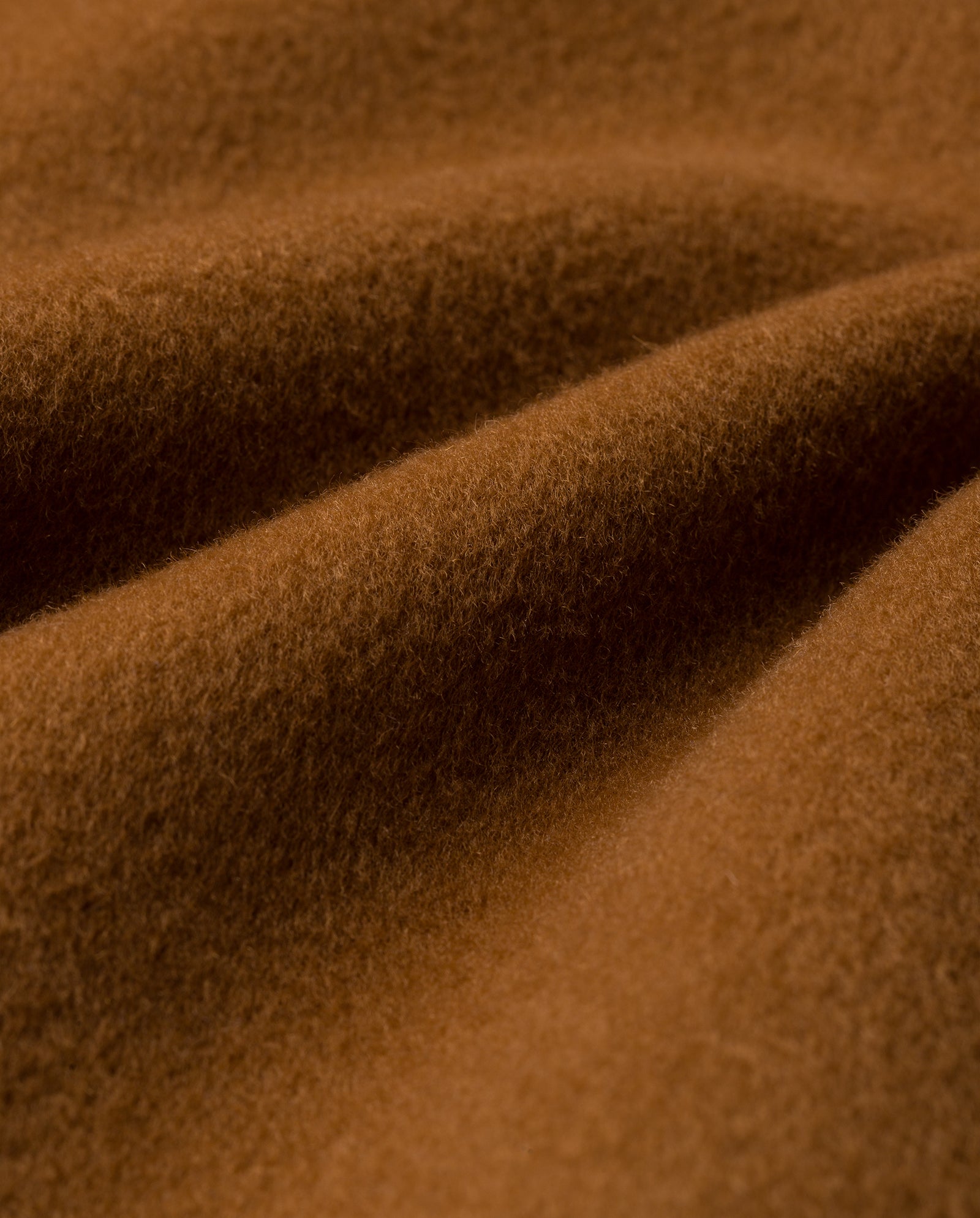 Close-up of the soft, brown fabric with gentle folds and a fuzzy texture used in the IVY OAK CARRIE ROSE Coat, crafted from Responsible Wool Standard wool for a minimalistic look.