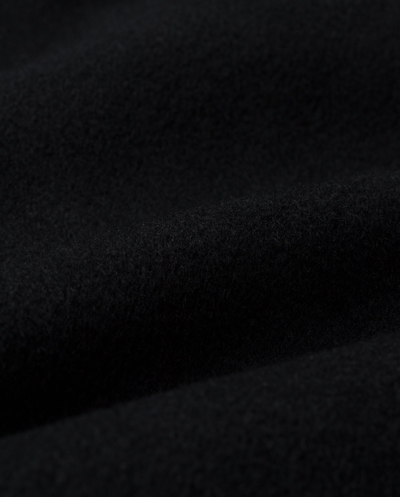 Close-up of soft, black fabric with gentle folds and a slightly fuzzy texture, crafted from RWS wool for the IVY OAK (DE) CLARISSA Vest.