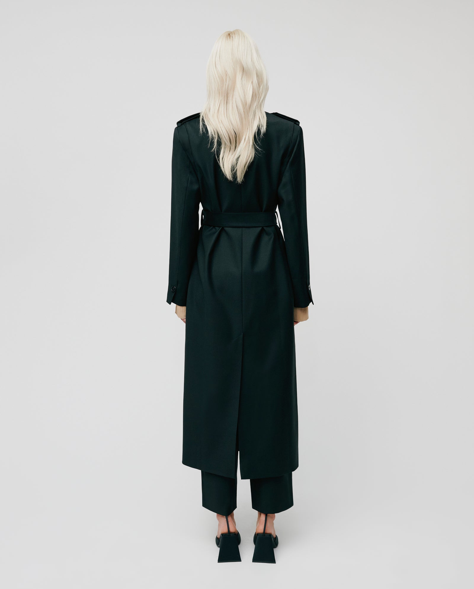 A person with long blond hair wears the oversized black COLETTE Coat by IVY OAK and matching pants, standing facing away against a plain background.
