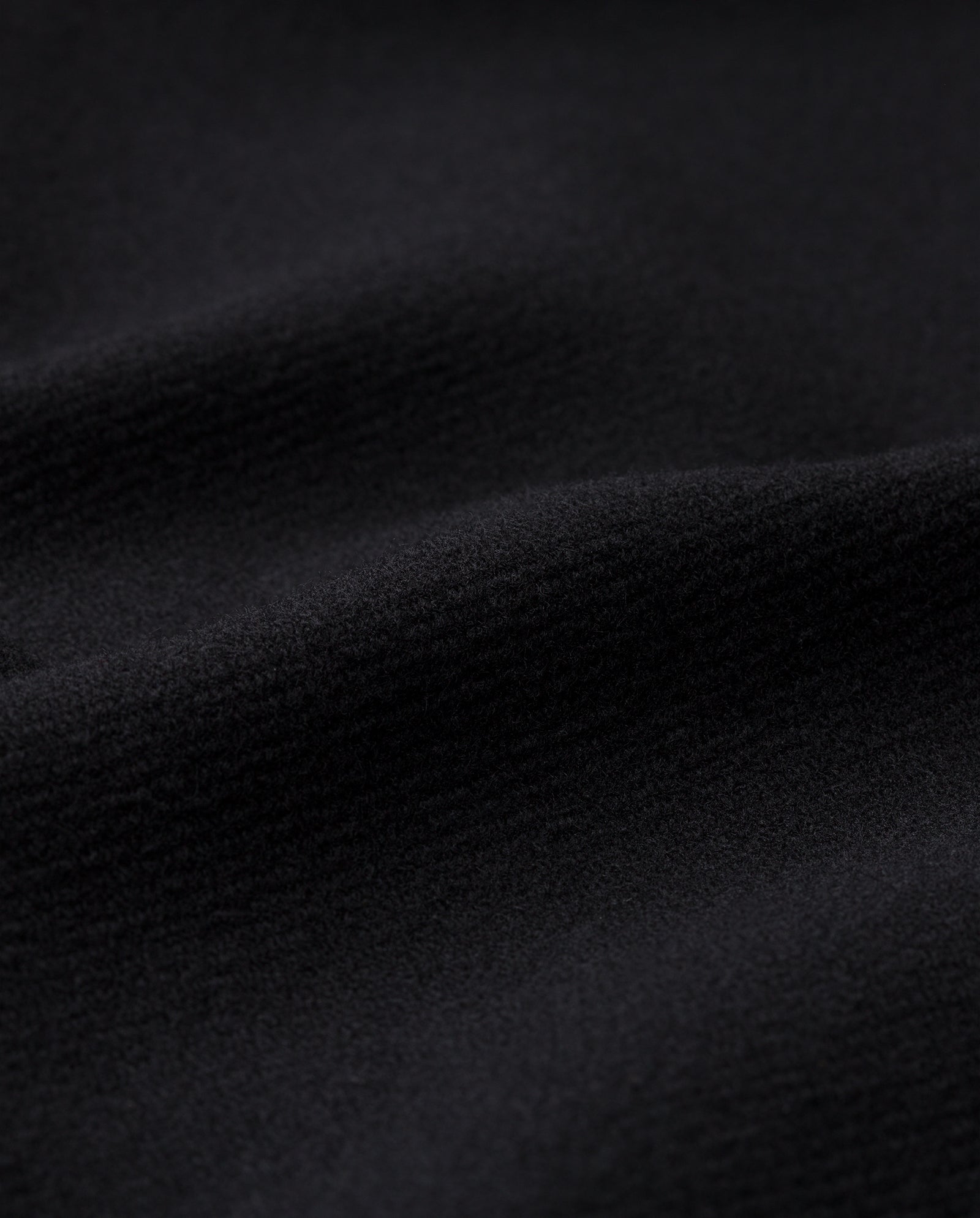 Close-up of the soft, black fabric with subtle waves and texture, highlighting the elegance of the IVY OAK CYNTHIA Coat.