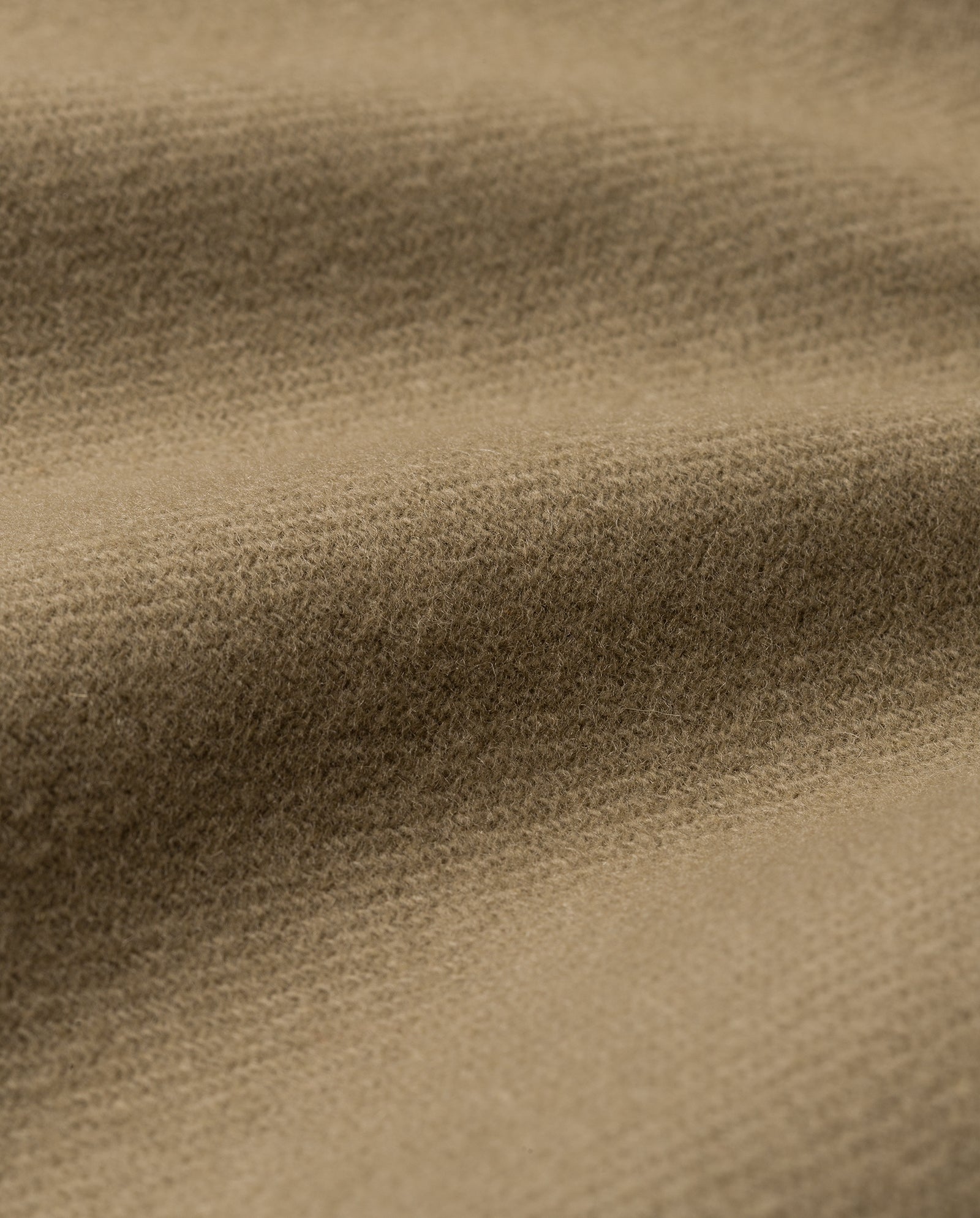 Close-up of light brown, textured fabric with soft, wavy folds from the CLEO Coat by IVY OAK, featuring an oversized design and a high stand-up collar for added structure and elegance.
