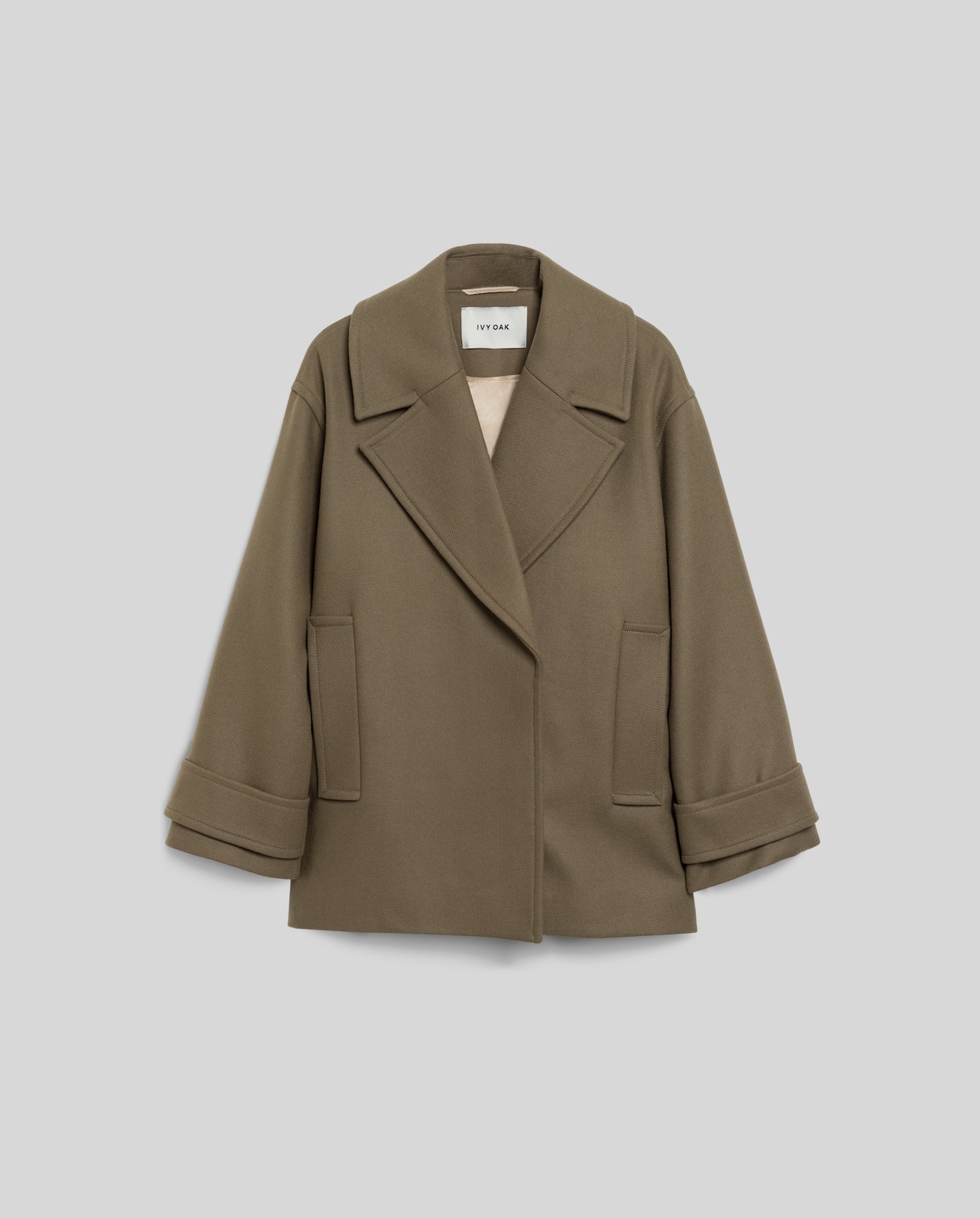 The IVY OAK CARLY Pea Coat is an olive green oversized wool coat with wide lapels, hidden button closure, and cuffed sleeves, shown on a light gray background.
