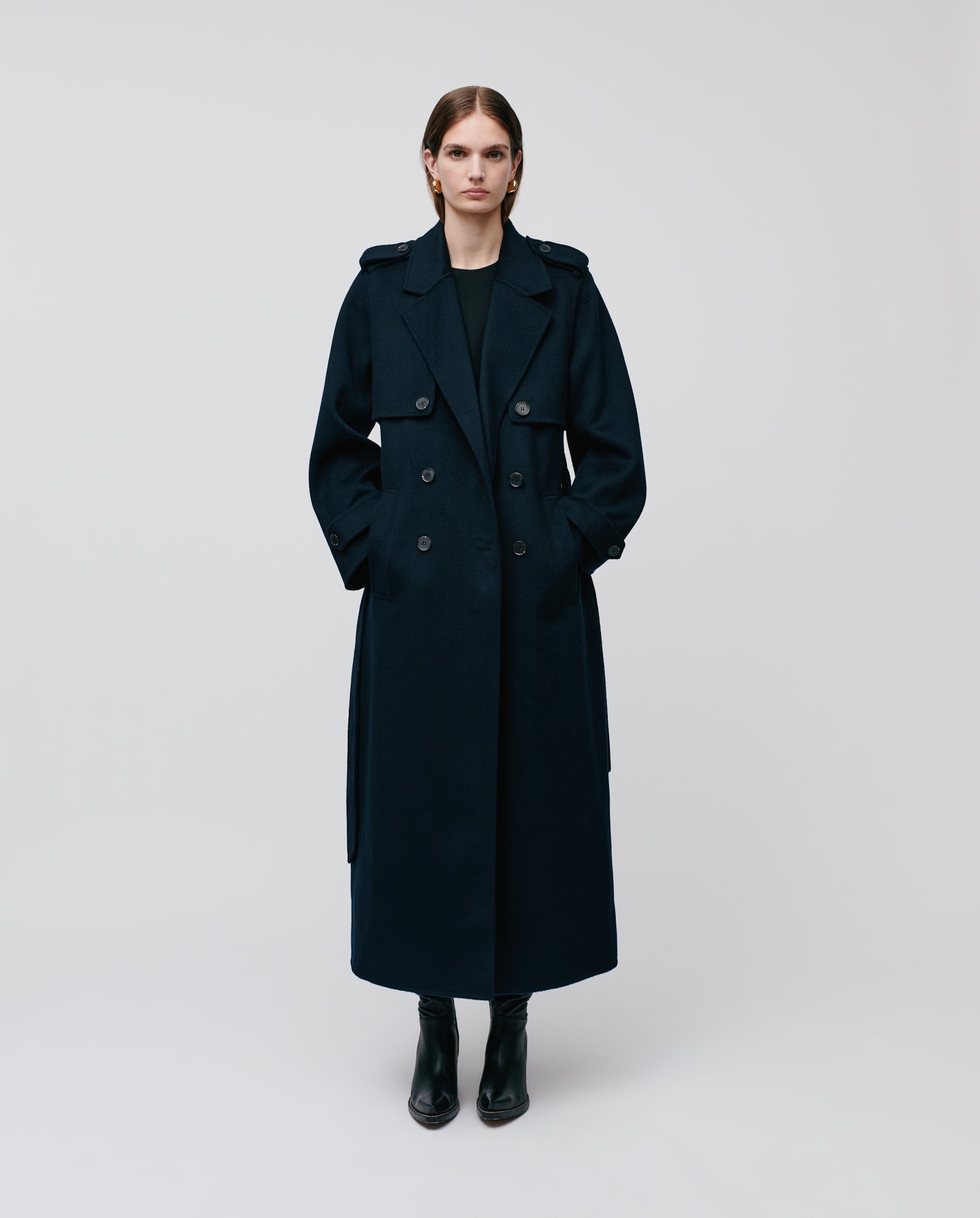 A person wearing the oversized COLETTE ANN coat by IVY OAK, made from Responsible Wool, paired with black boots, stands against a plain background.