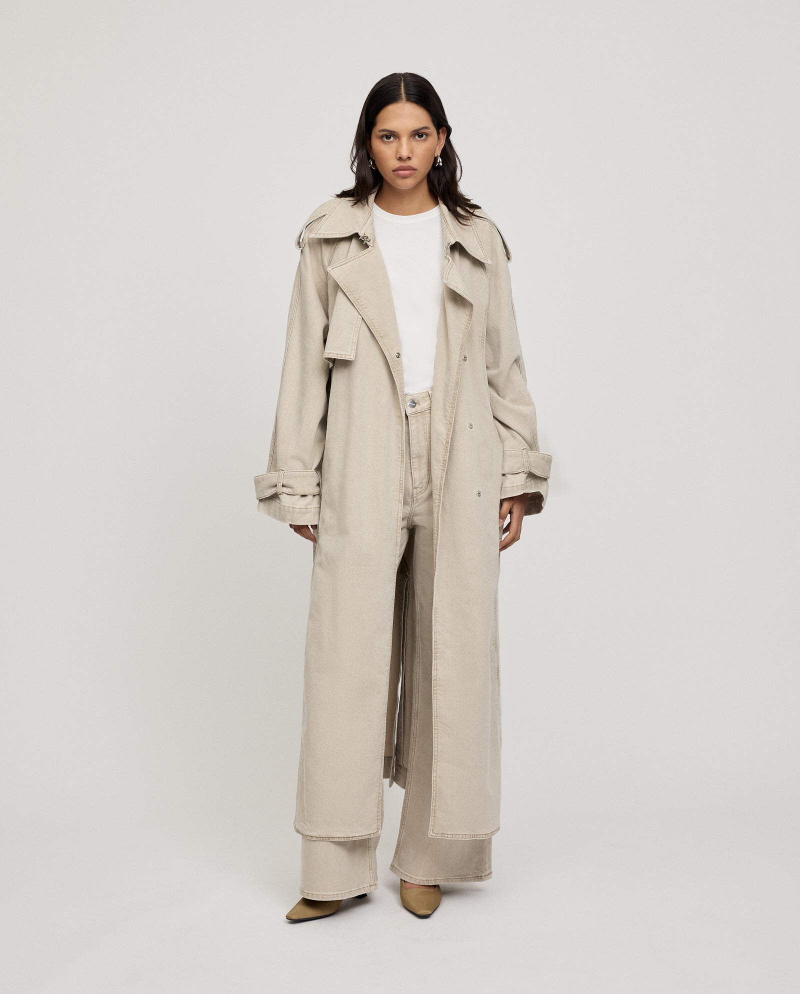 A woman in the IVY OAK CORDELIA oversized coat with front pockets, a white shirt, and wide-leg pants stands against a plain background.
