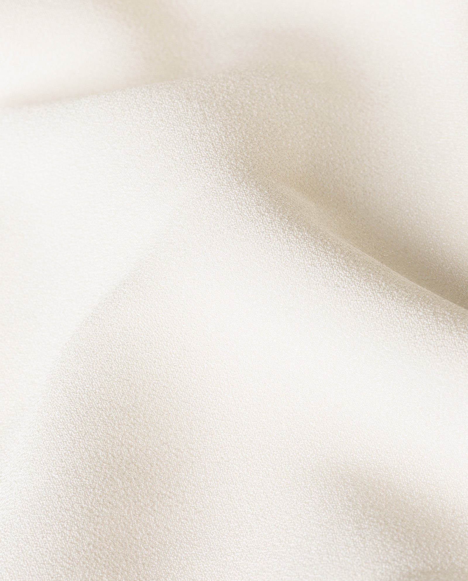 Close-up of the DARIA Bridal Dress by IVY OAK, featuring soft off-white satin with subtle texture and gentle folds—ideal for a maxi wedding gown with customizable lengths.