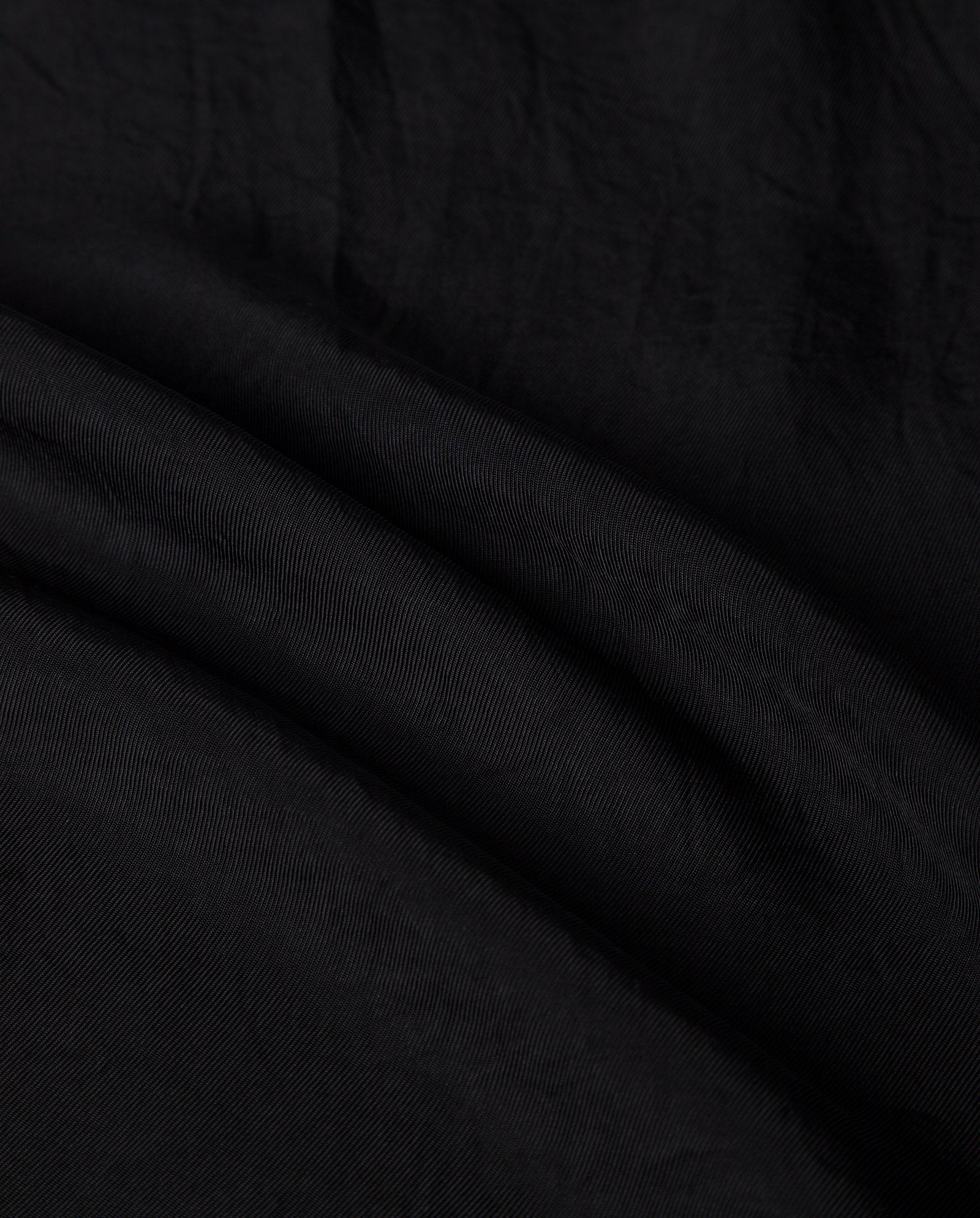 Close-up of black Naia acetate fabric with subtle texture and gentle folds, highlighting the elegance of the IVY OAK TILDA ANN Top.