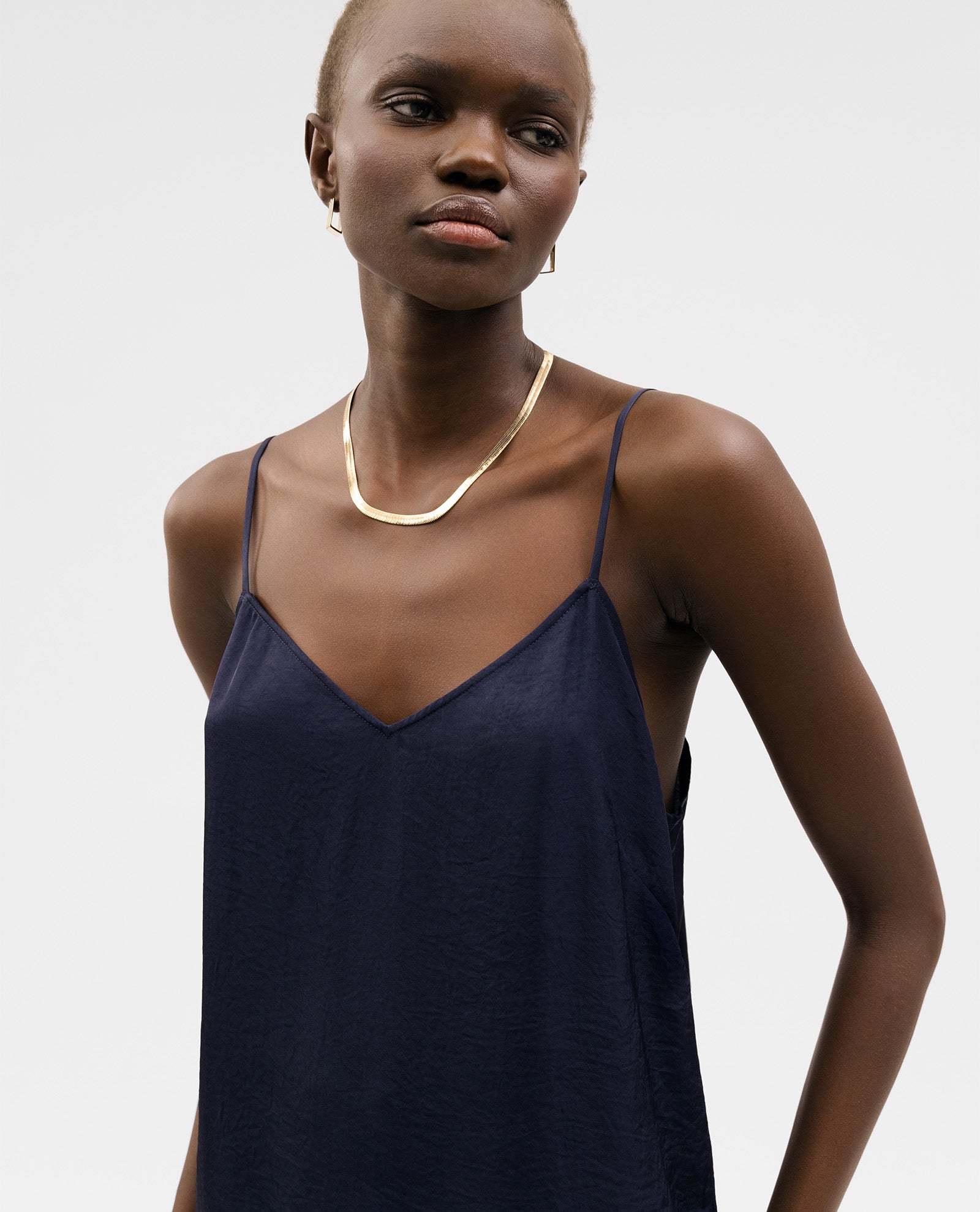 A woman in an IVY OAK TILDA ANN Top stands against a plain white background, wearing a gold necklace.