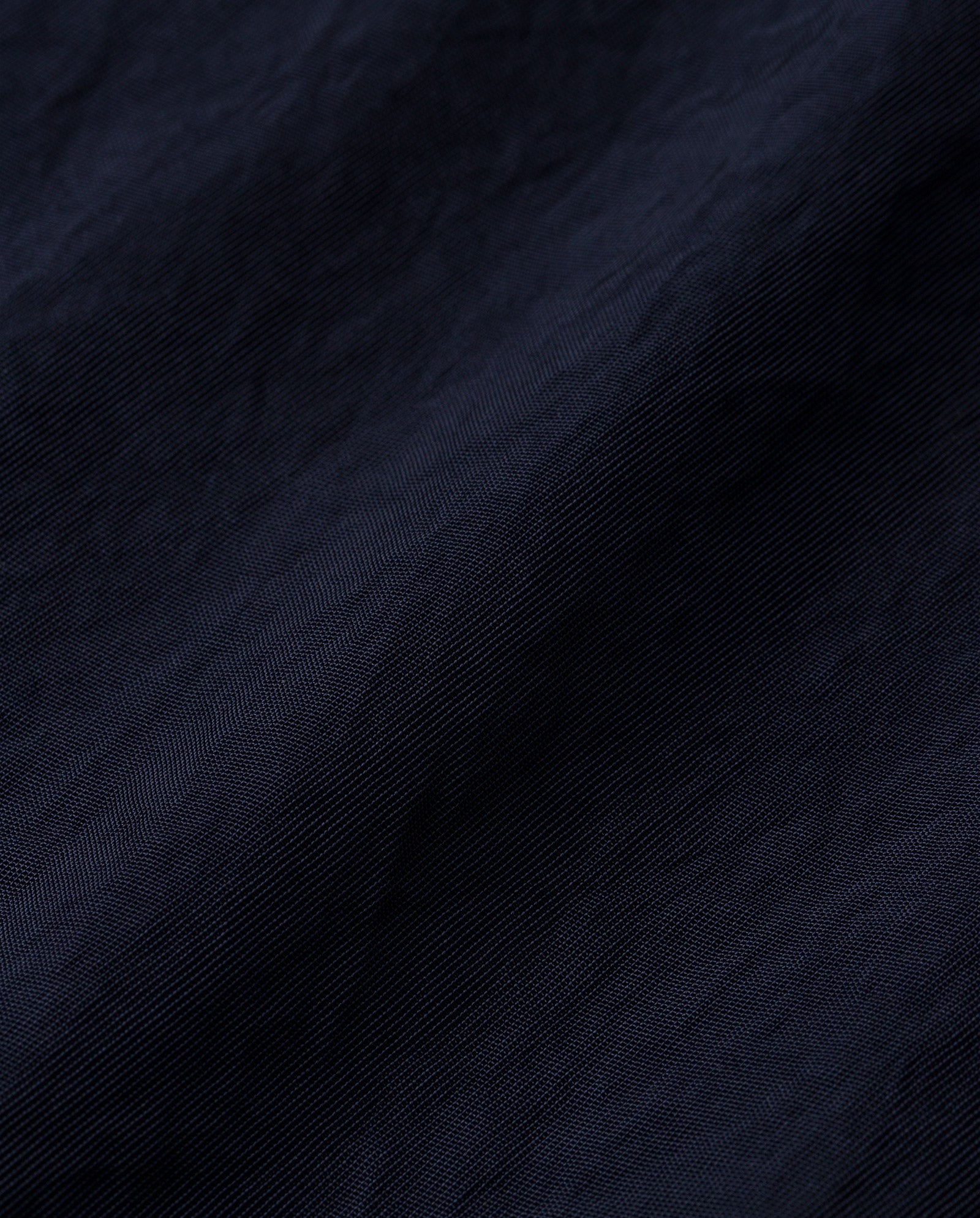 Close-up of the TILDA ANN Top by IVY OAK, featuring dark blue textured Naia acetate fabric with soft, wavy folds and fine lines.