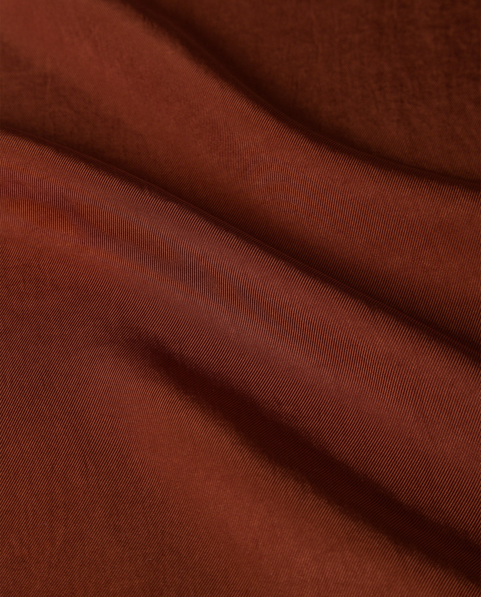 Close-up of smooth, brown Naia™ acetate fabric with gentle folds and subtle texture, featured in the IVY OAK TILDA ANN Top.