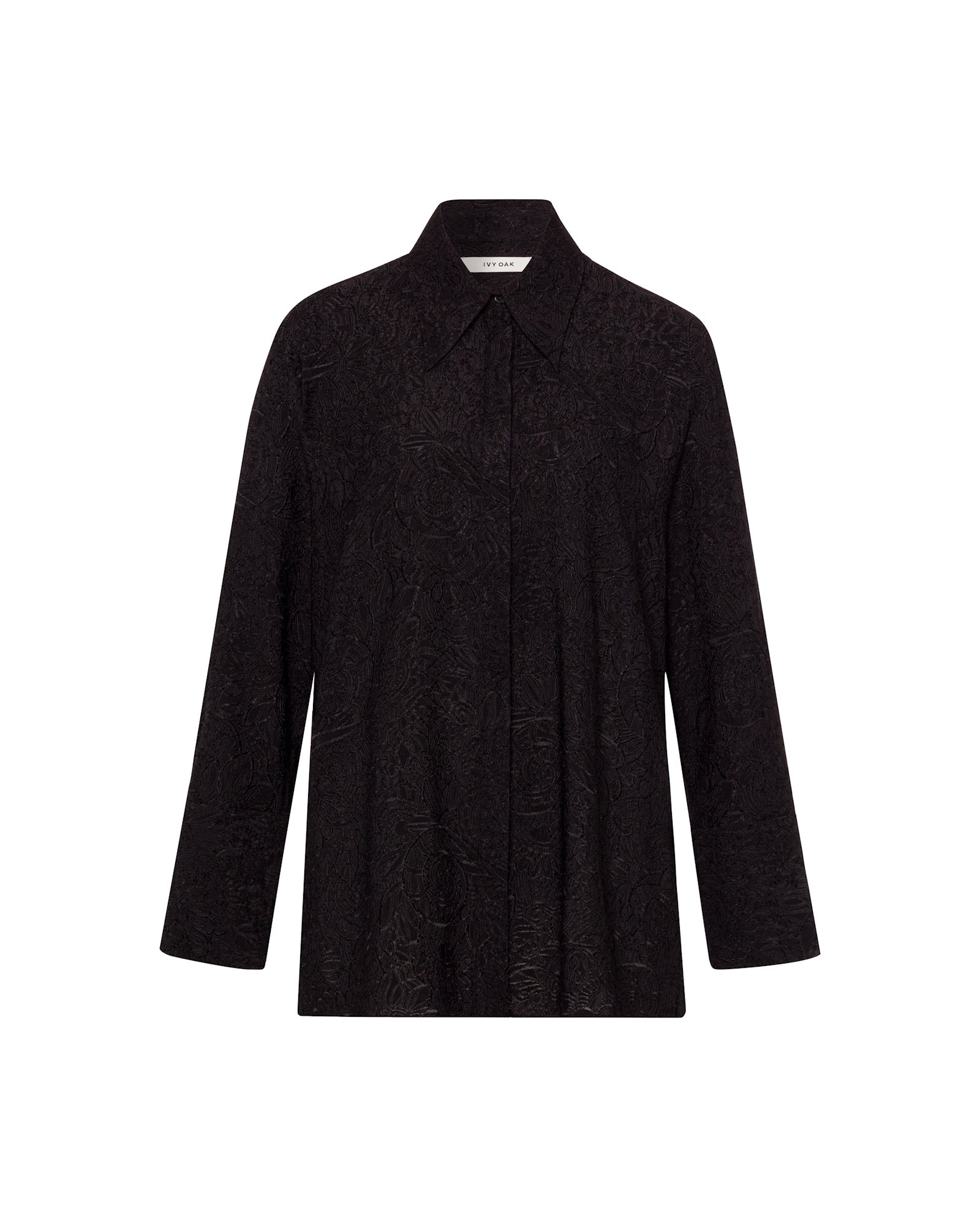 The ELVIE ANN Blouse by IVY OAK is a black long-sleeve top with a wide collar and a subtle textured floral fil coupé pattern, shown on a white background.