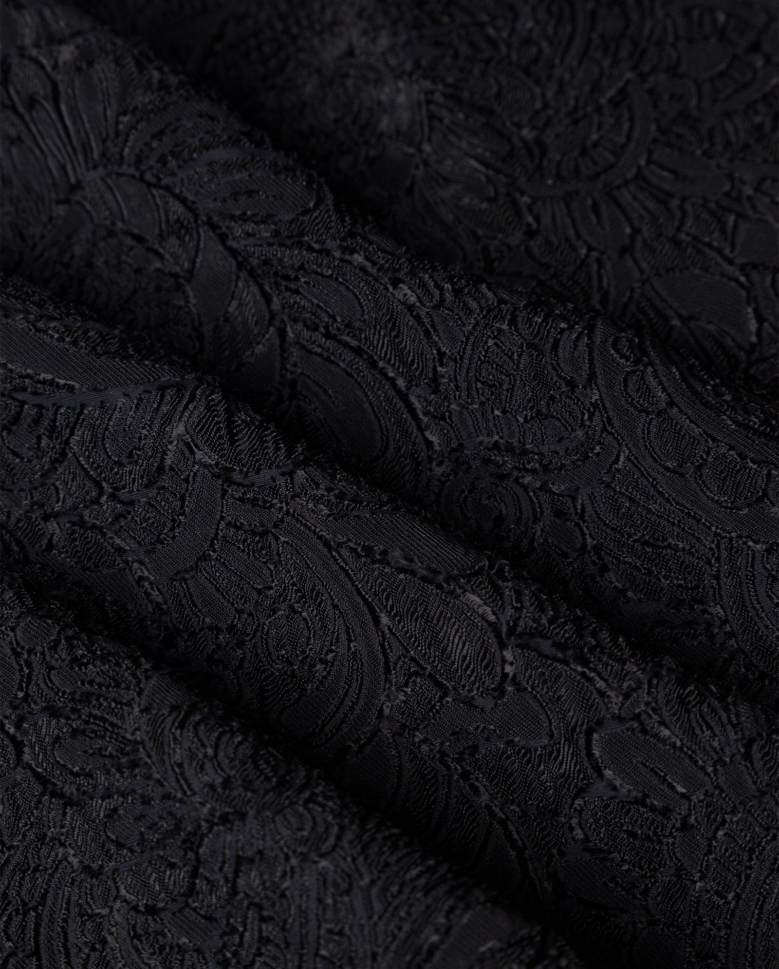 Close-up of the ELVIE ANN Blouse by IVY OAK, featuring folded black fabric with an intricate floral jacquard texture—ideal for statement blouses or adding elegance to wide collars.