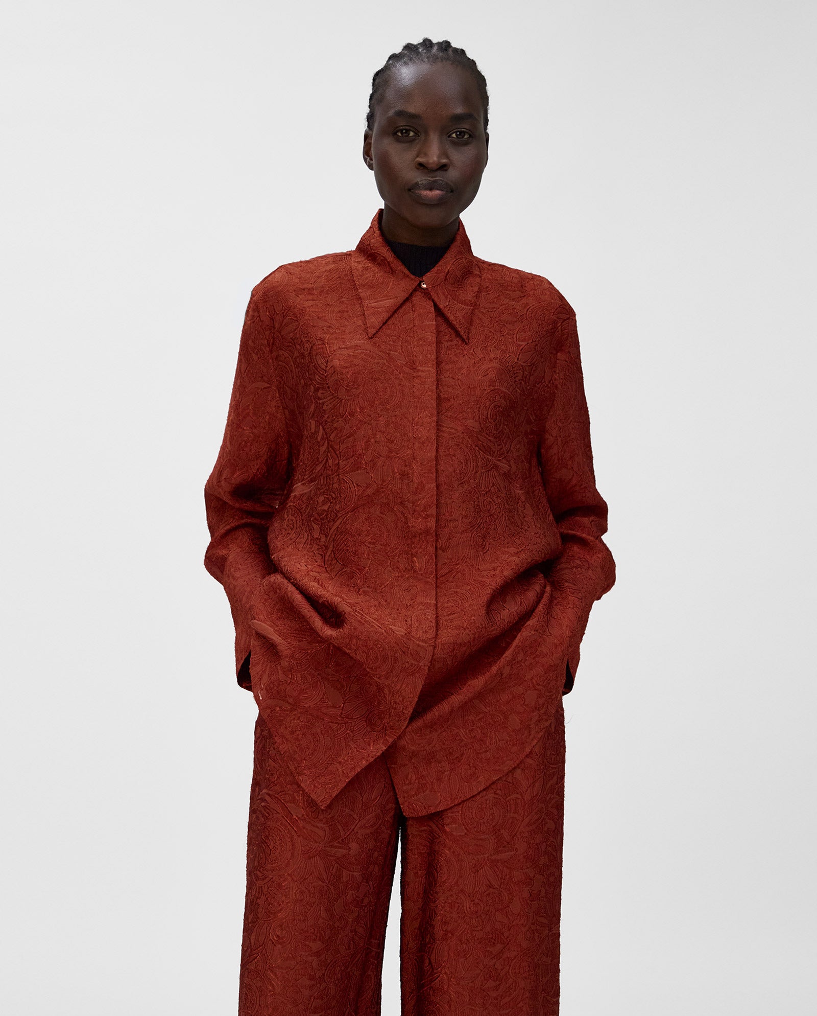 Wearing the IVY OAK ELVIE ANN Blouse with a wide collar and matching pants, hands in pockets, creates a chic monochrome look against a plain background.