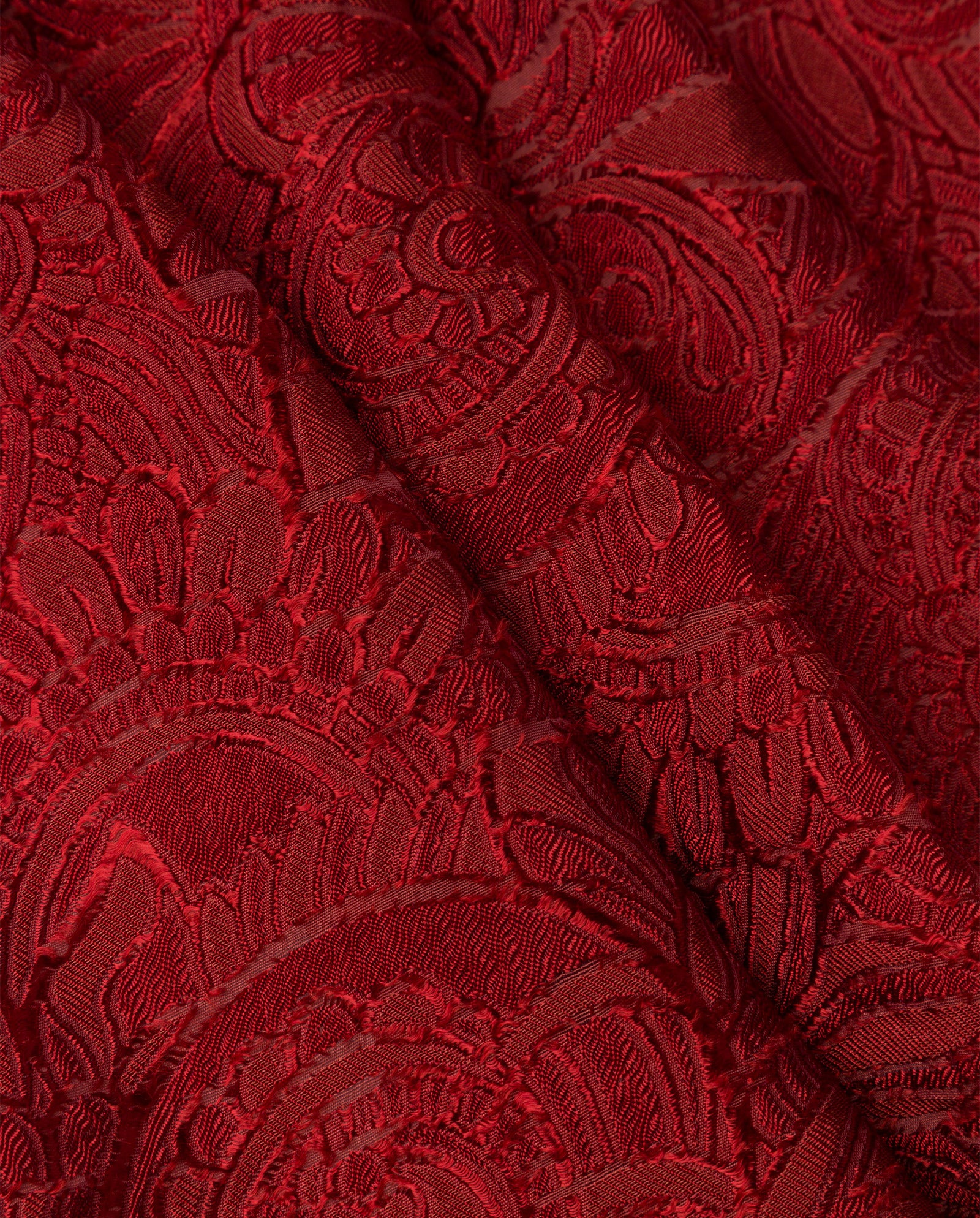 Close-up of luxurious red fabric featuring an ornate, raised floral and swirl pattern—ideal for the IVY OAK ELVIE ANN Blouse or creating a bold monochrome style.