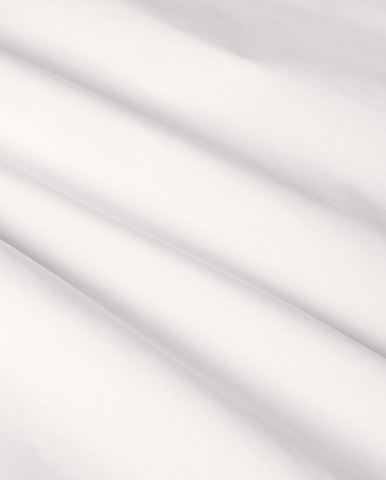 Smooth, white fabric with soft folds and gentle diagonal shadows, inspired by the understated elegance of the IVY OAK ESTELLE Top’s hidden button placket.