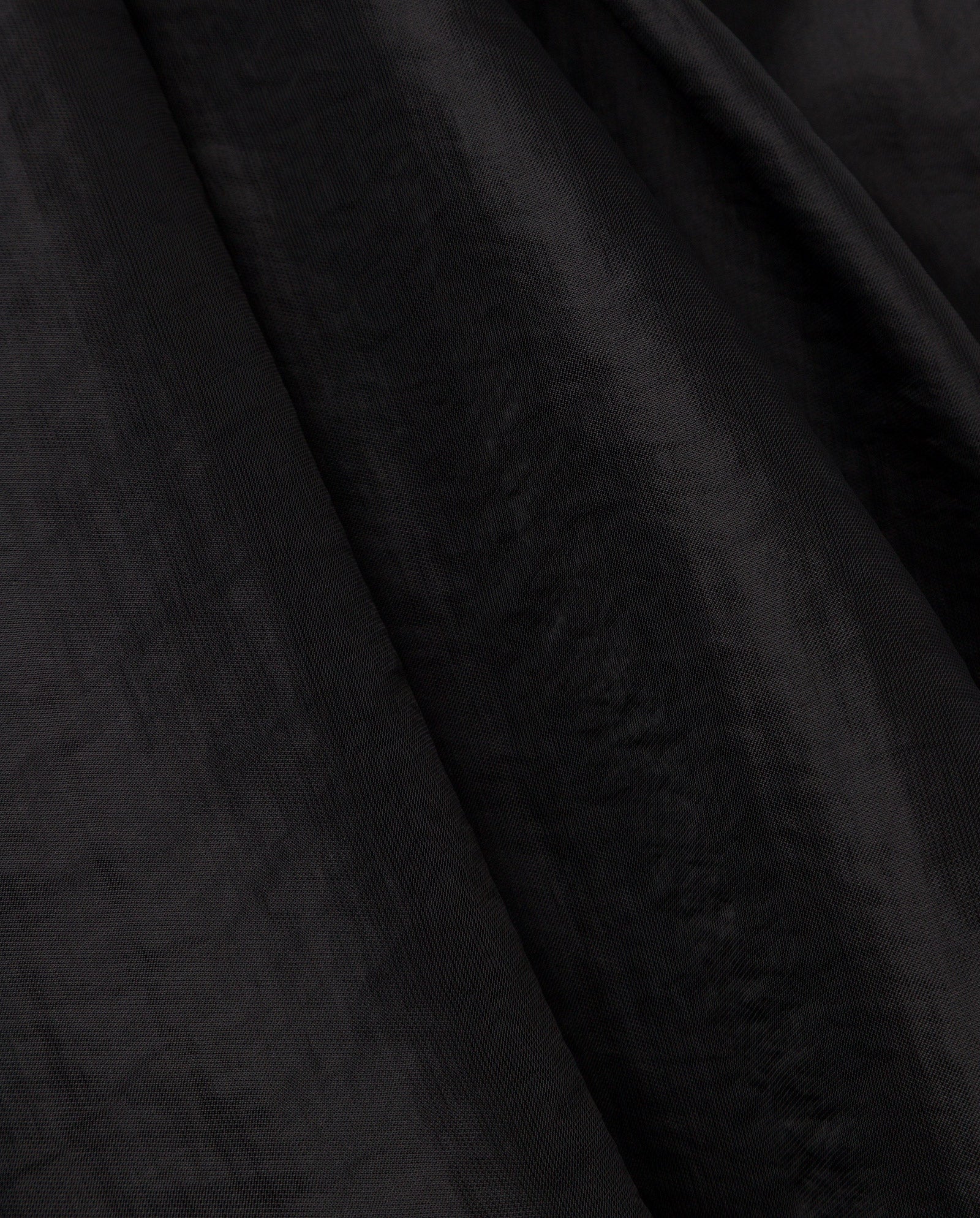 Close-up of black textured fabric with soft folds and subtle sheen, evoking the elegance of the IVY OAK EBONEY Blouse.
