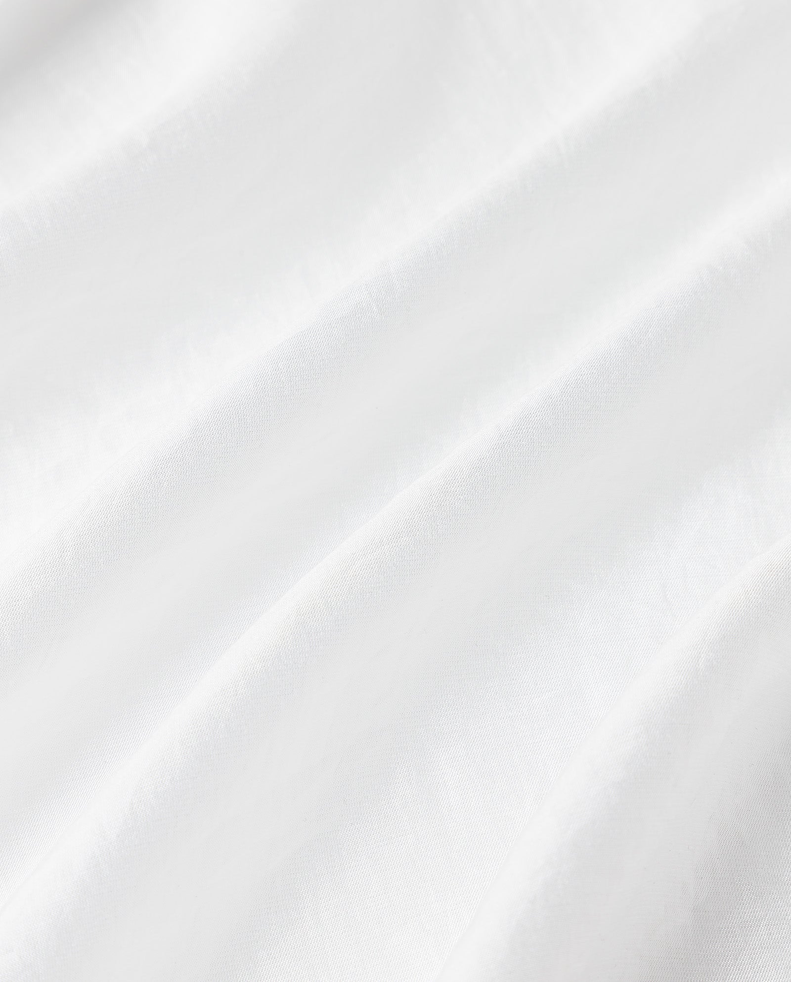 Close-up of white, softly wrinkled organza material with gentle folds and smooth texture, as seen on the ELOISE MAY Blouse by IVY OAK.