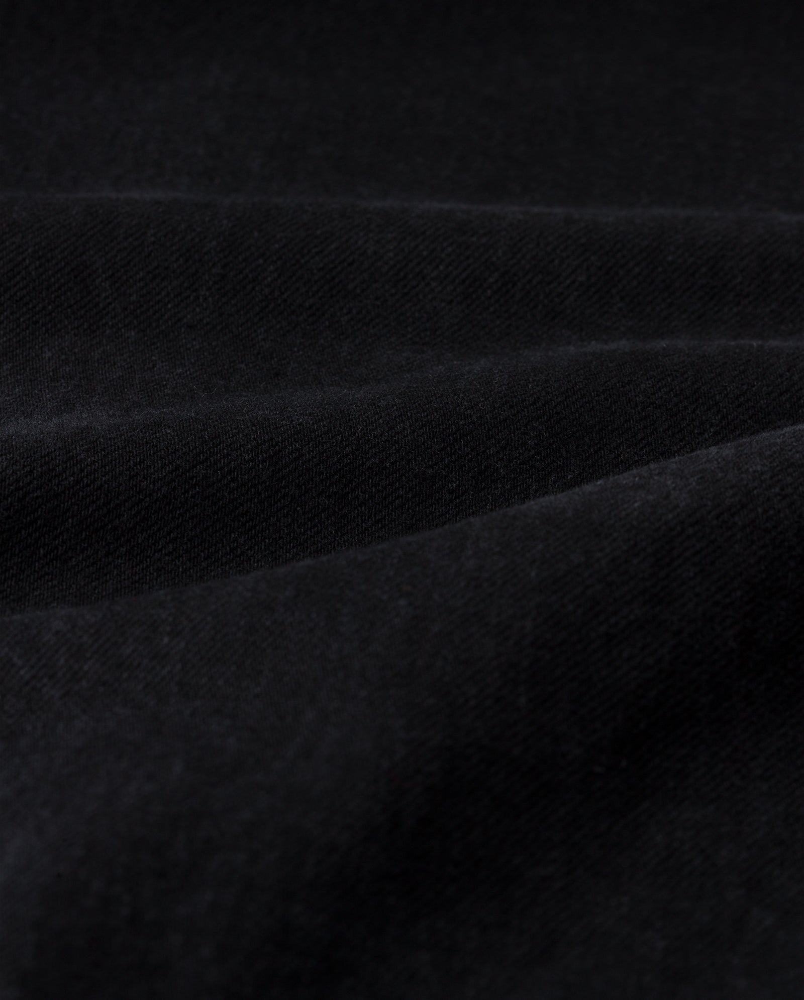 Close-up of the BERENICE Blouse by IVY OAK, featuring soft black fabric with gentle folds and a velvety texture reminiscent of washed denim’s smooth finish.