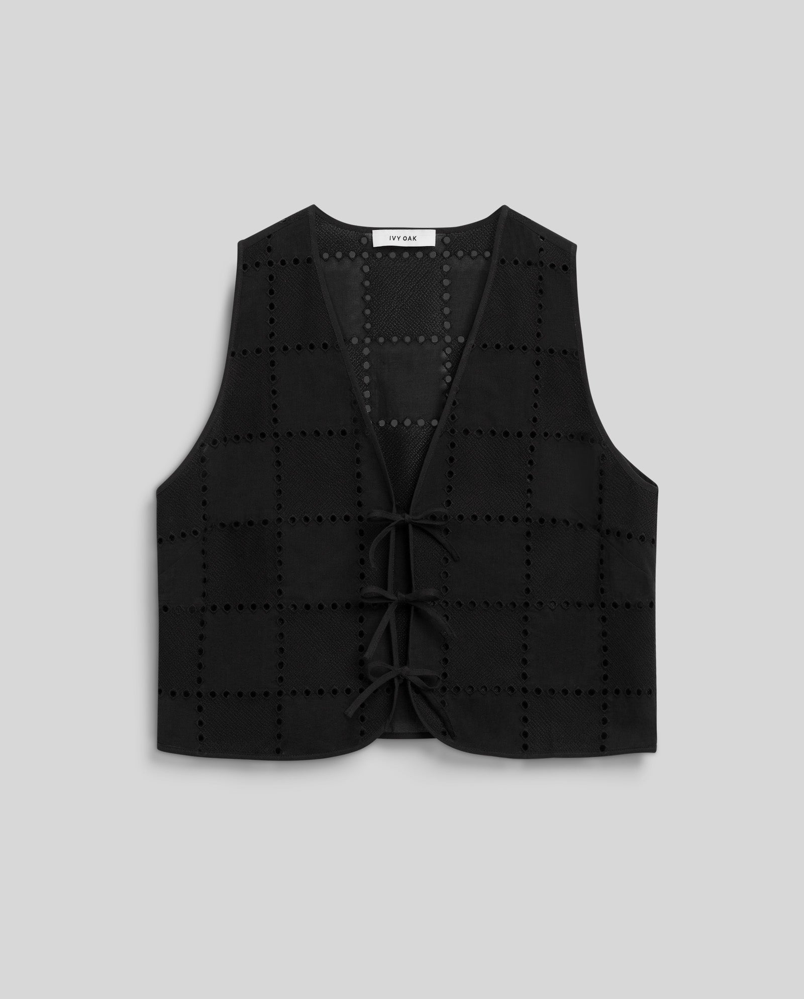 Sleeveless black IVY OAK TALA Top with grid pattern and lace-up front ties, shown on a plain gray background.