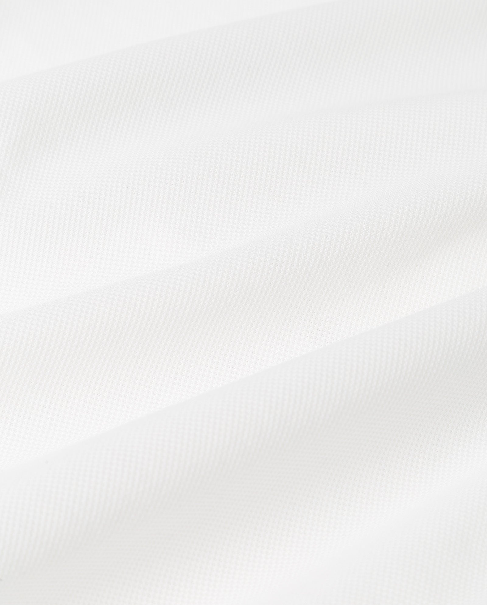 Close-up of white organic cotton fabric with gentle folds and diagonal lines, ideal for the FABIOLA ANN Top by IVY OAK.