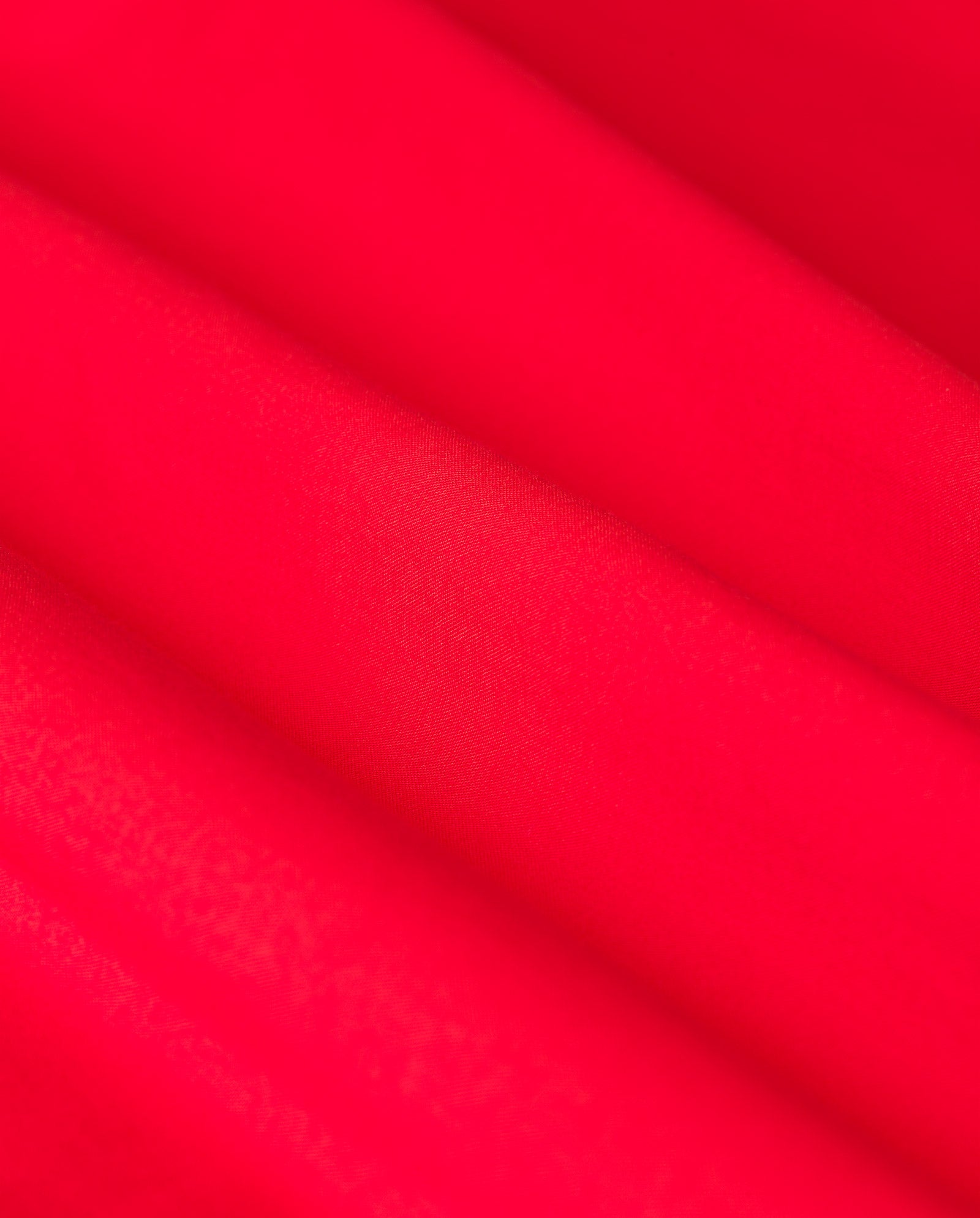 Close-up of the ELISABETH ANN Blouse by IVY OAK, featuring bright red cropped cotton fabric with diagonal folds that highlight its soft, smooth texture.